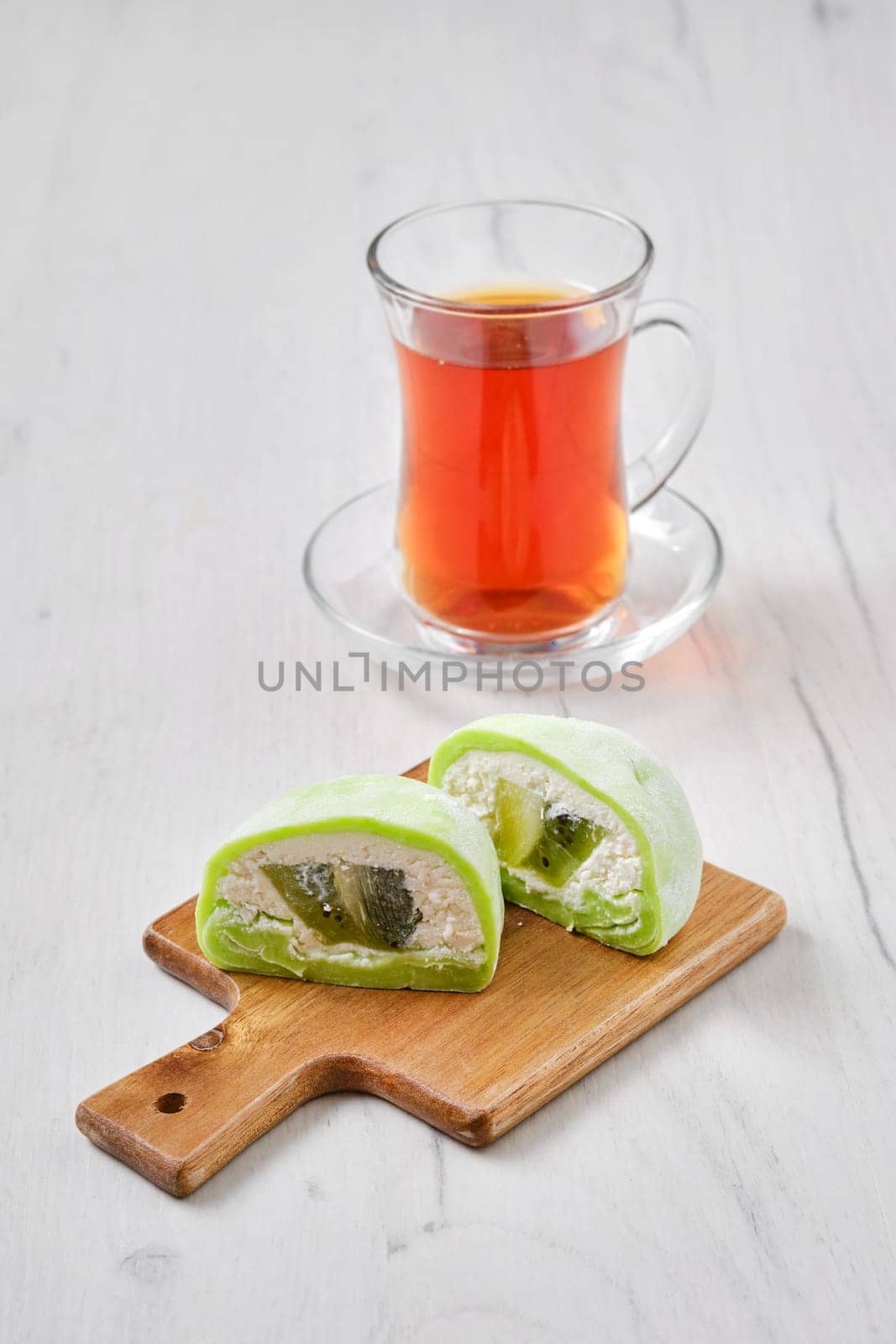 Sweet dessert mochi with kiwi cut on half with fruit tea