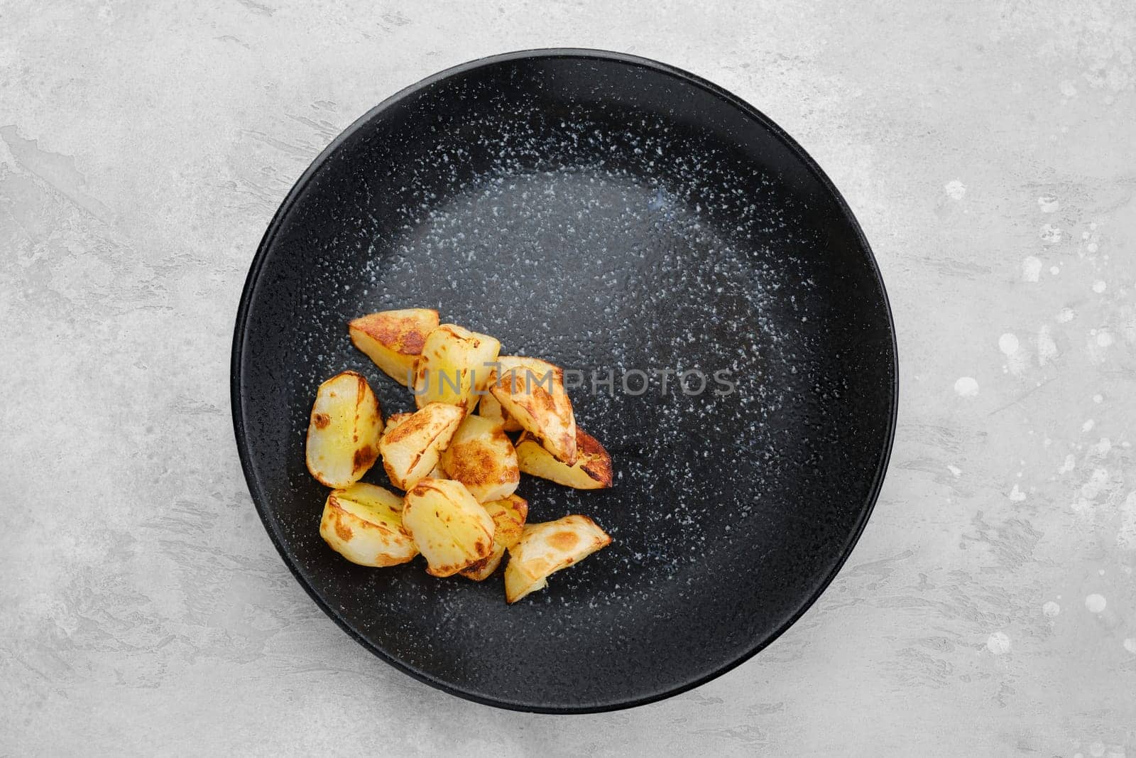 Garnish to the main dish - slices of boiled potatoes fried in oil, top view
