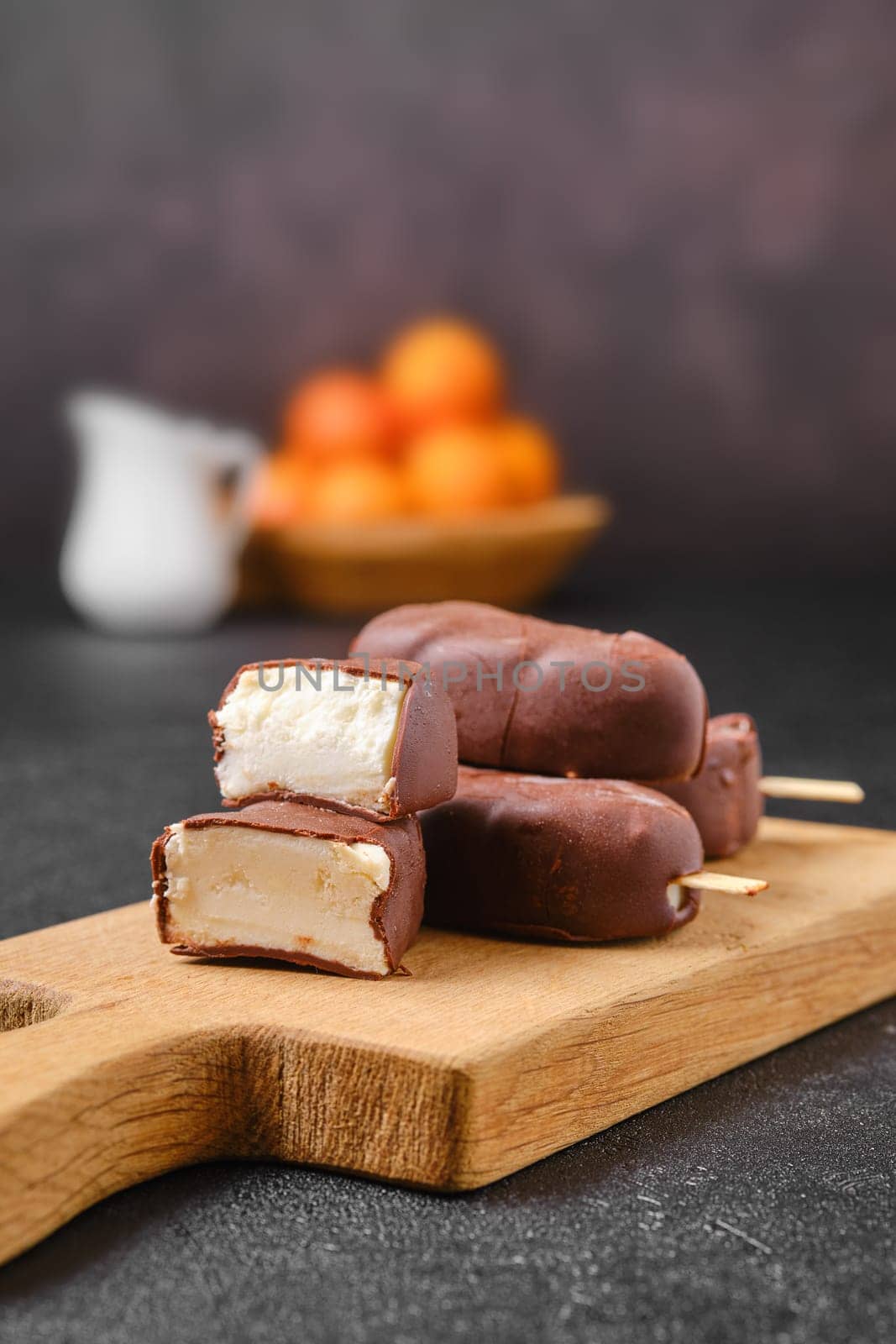 Homemade curd bars in chocolate on wooden board (soft focus photo)