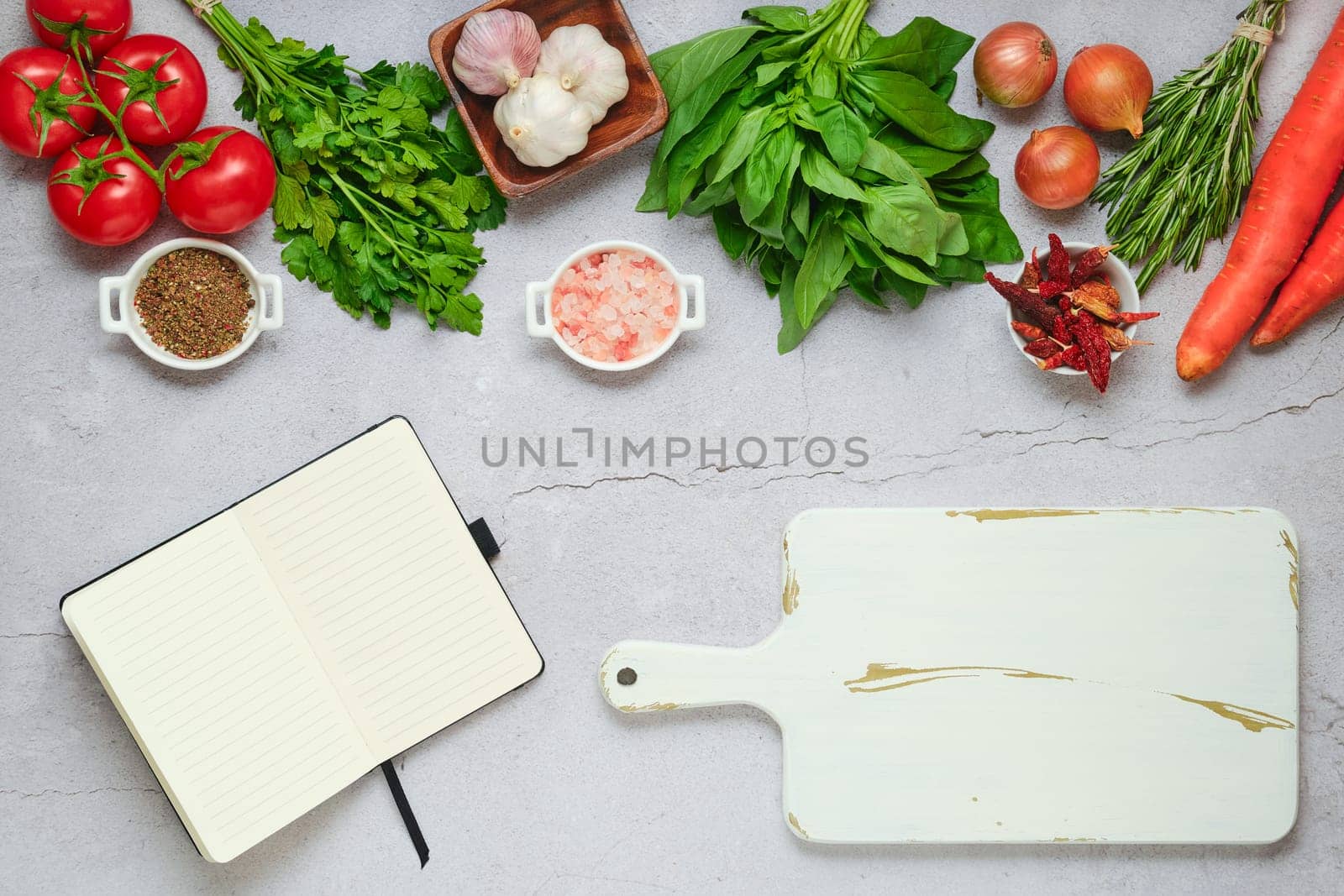 Diet food concept of healthy eating. Opened notebook next to cutting board and fresh vegetables and herbs