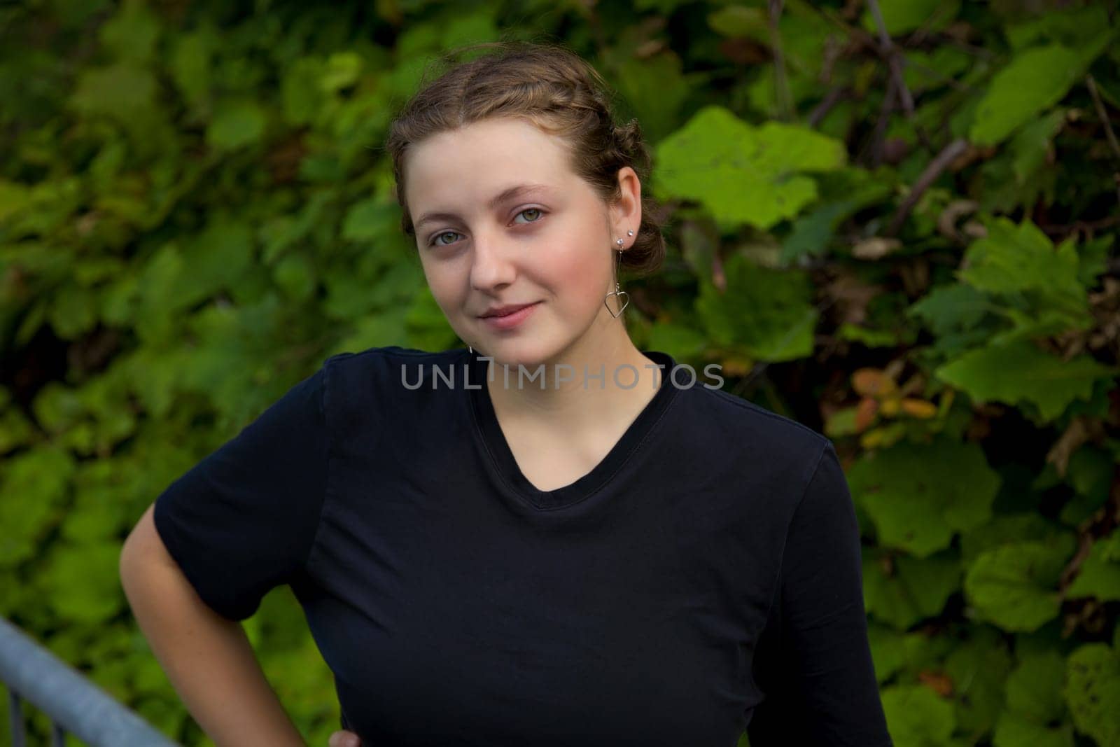 blonde teenager woman around 20 standing green vegetation natural background