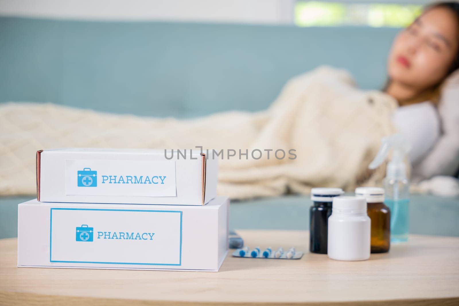 Asian young woman cold sick she sleeping and resting on sofa after take pills at home, beautiful female health problem use pharmacy kit box delivery service from hospital, delivery pharmacy concept