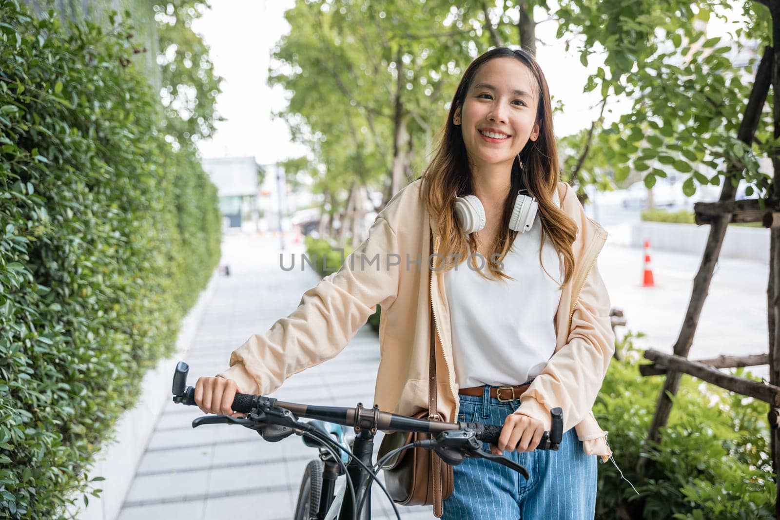 Lifestyle Asian young woman walking alongside with bicycle on summer in countryside outdoor, Happy female smiling walk down the street with her bike on city road, ECO environment, healthy travel