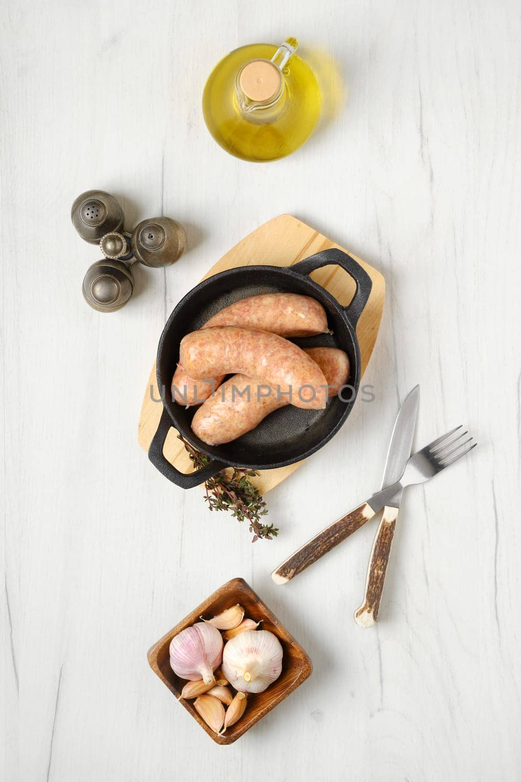 Raw traditional homemade British banger pork sausage ready for frying on wooden table