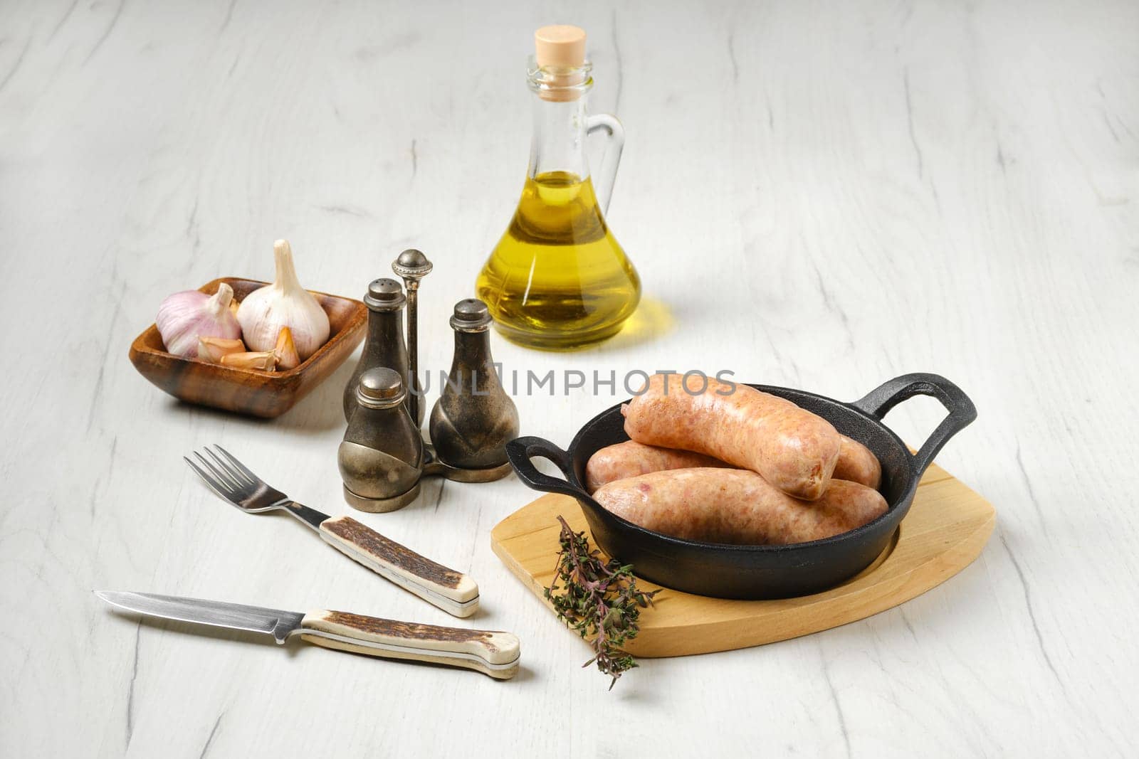 Raw traditional homemade British banger pork sausage in cast-iron skillet ready for frying