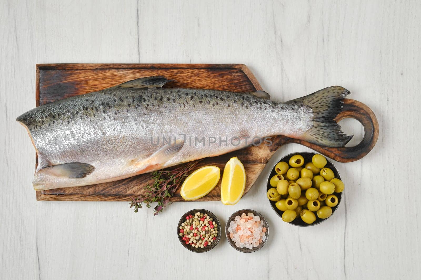 Headless fresh yellow tailed lacedra on wooden cutting board, top view