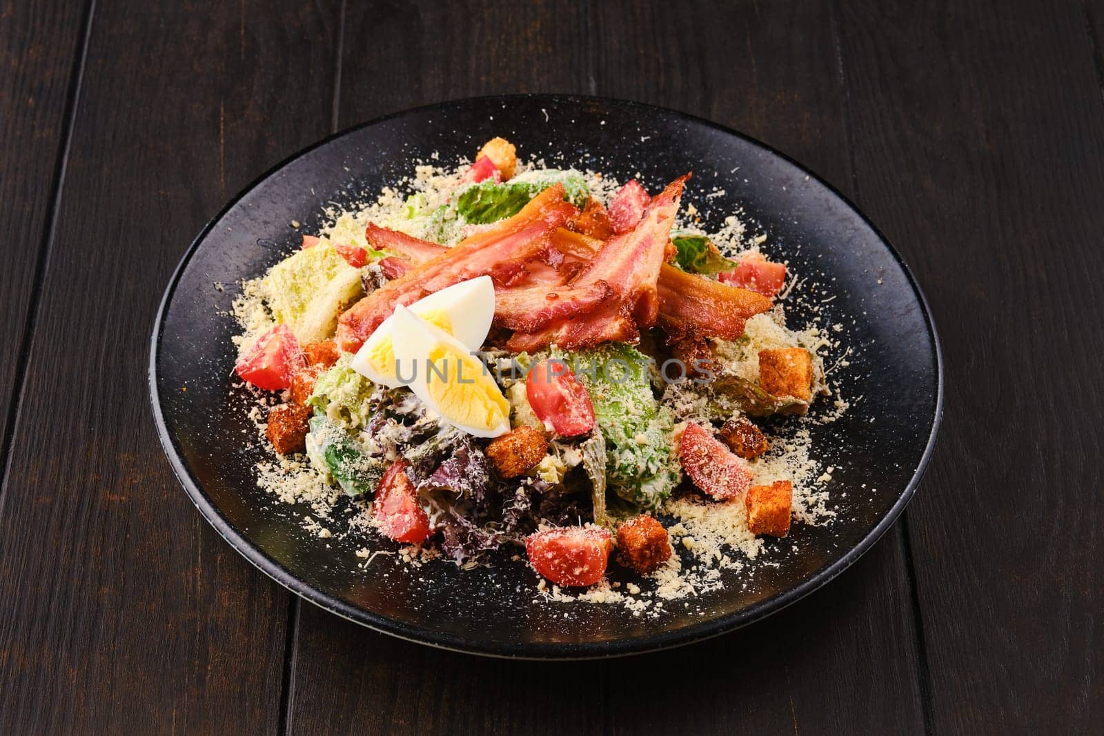 Salad with bacon, egg, fresh vegetables, croutons and grated cheese