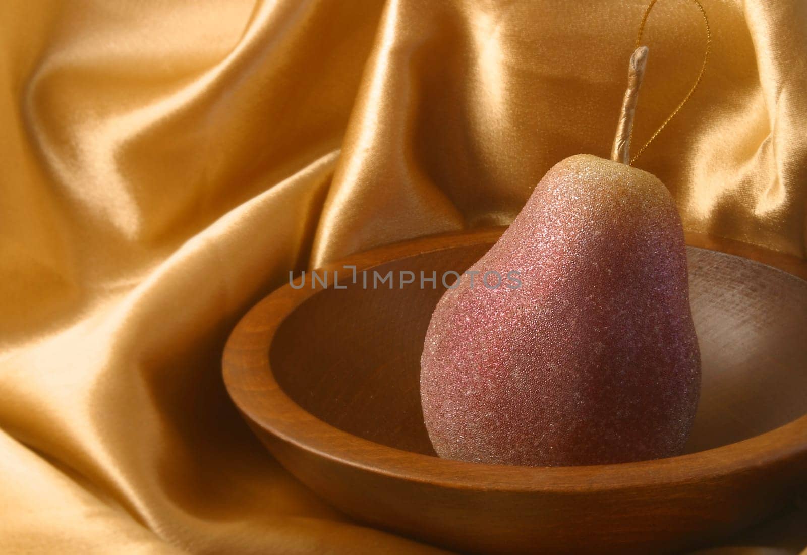 A pear ornament in a wooded bowl