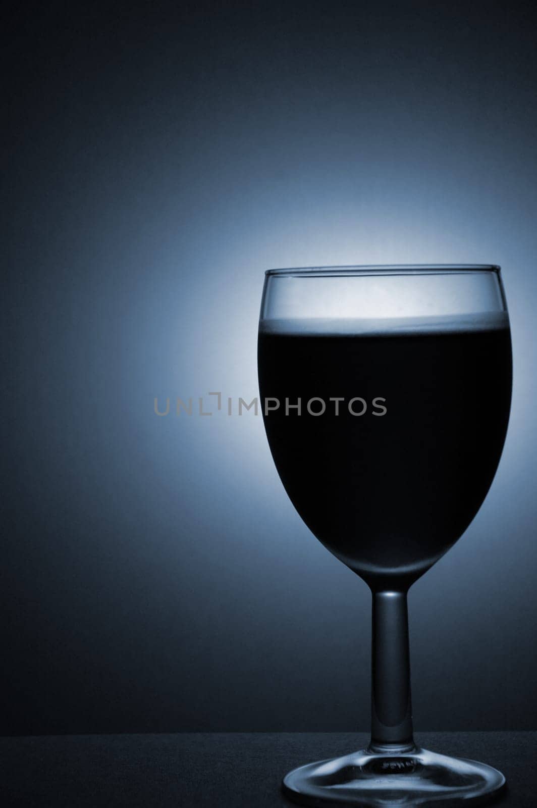 A studio photograph of a wine glass containing wine.