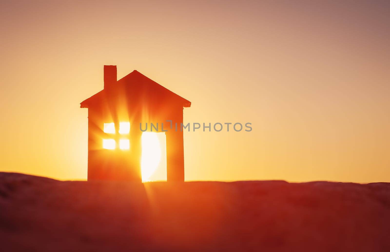 Model of a house standing on the ground on sunset evening. Concept of buying or selling a new appartment.