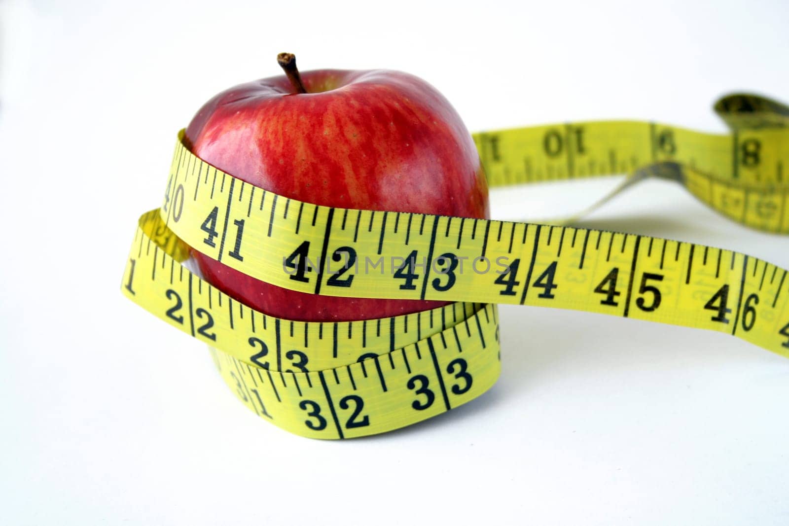 Isolated Apple with measuring tape around in white background