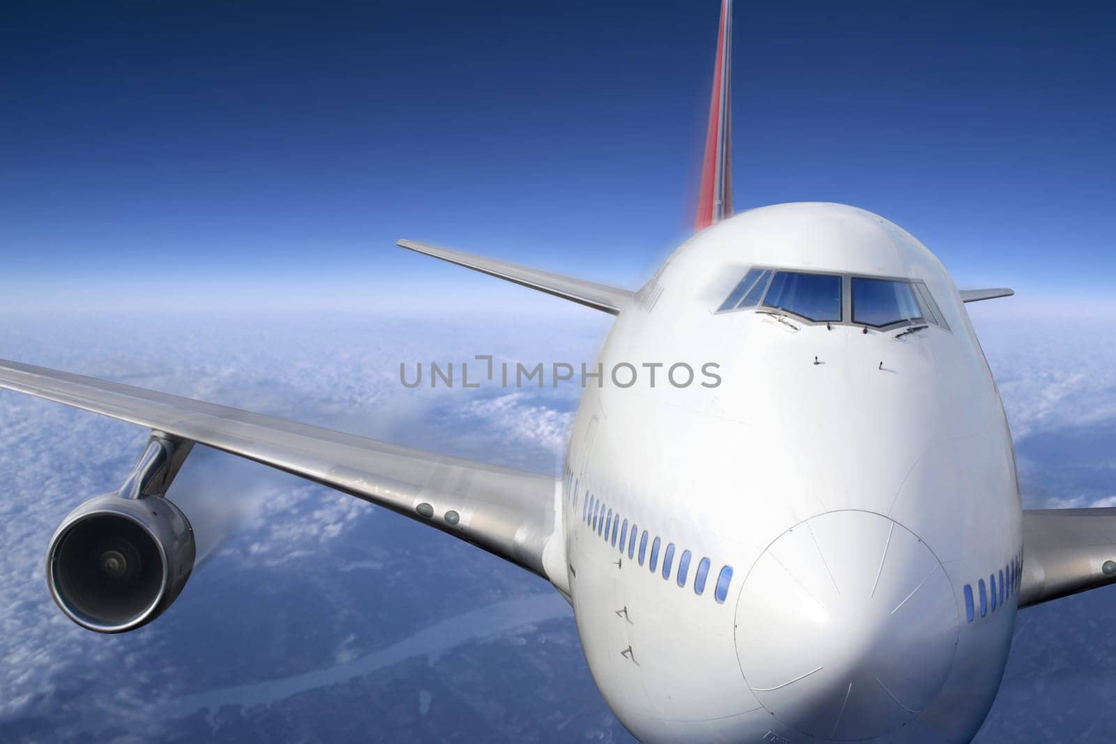 A passenger jet flying high above the clouds.