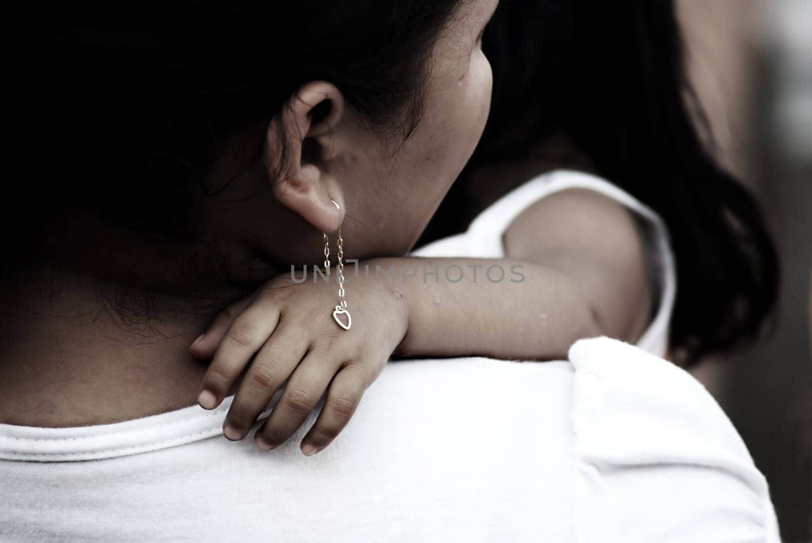 mother holding her child, earrings on childs hand