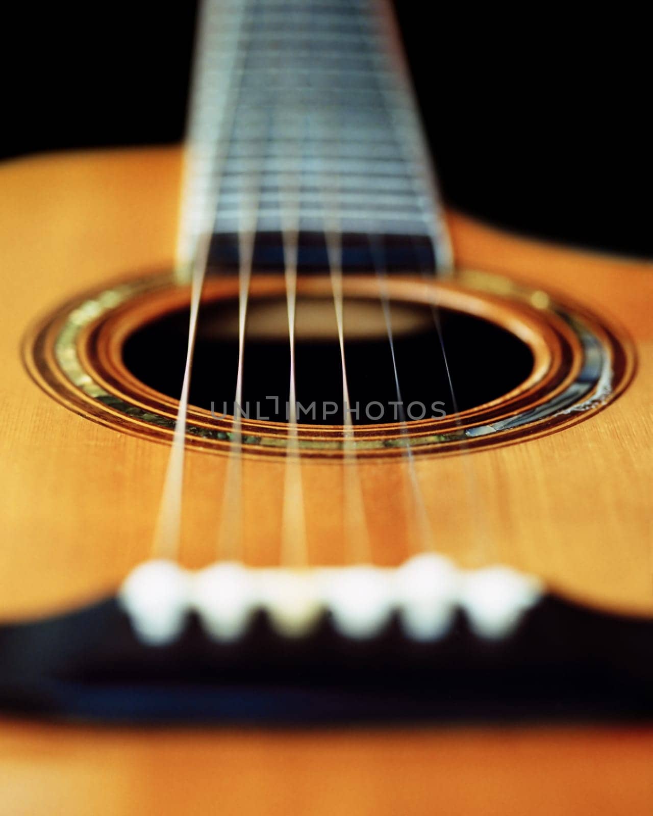A very short depth-of-field image of an acoustic guitar from the bridge looking up the neck.  Scanned from film.