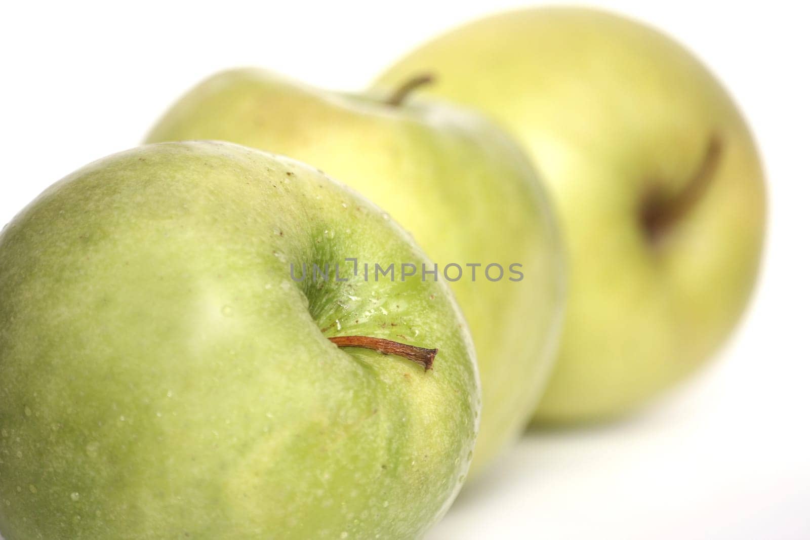 Three green apples in a number on a white background