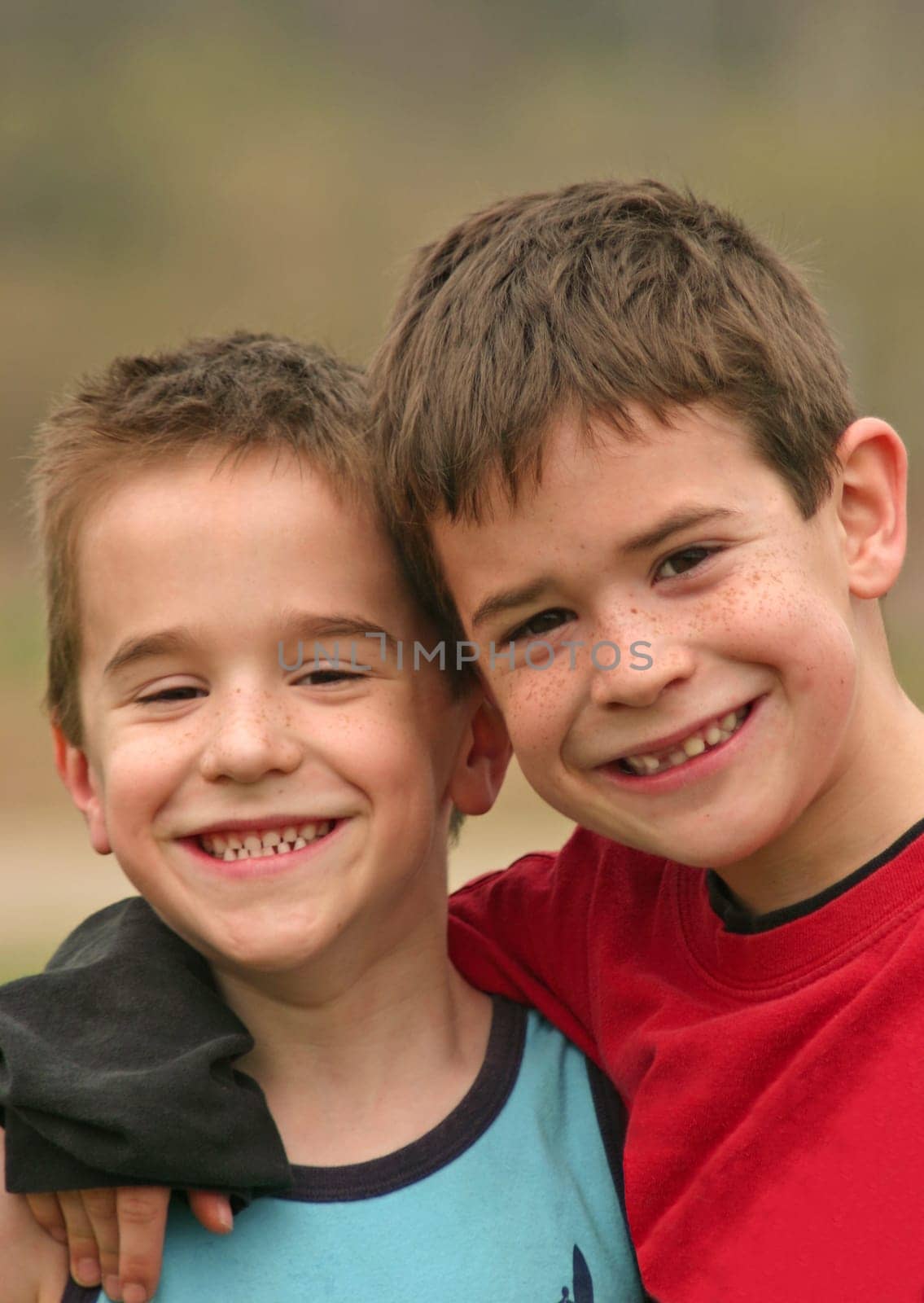 Two Brothers smiling with their arms around each other