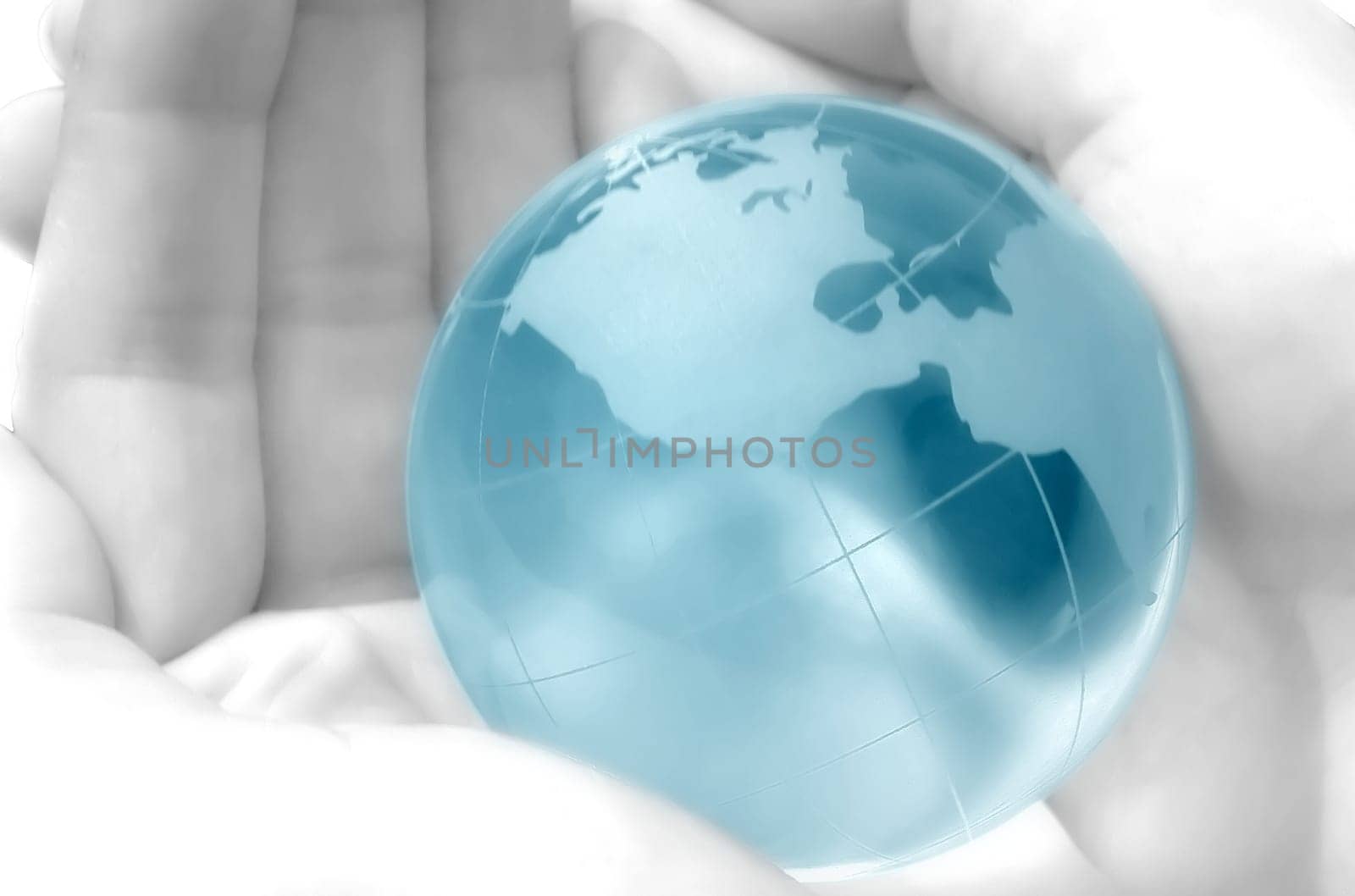 hand holding a blue globe, blurred, dreamy atmosphere