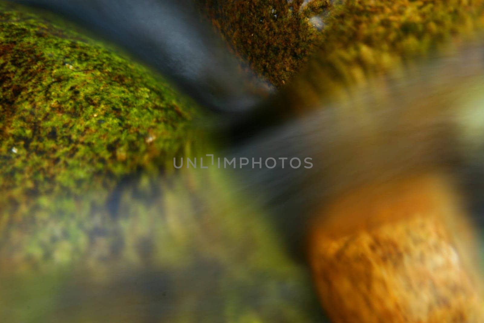 long exposure of water flowing over colourful rocks