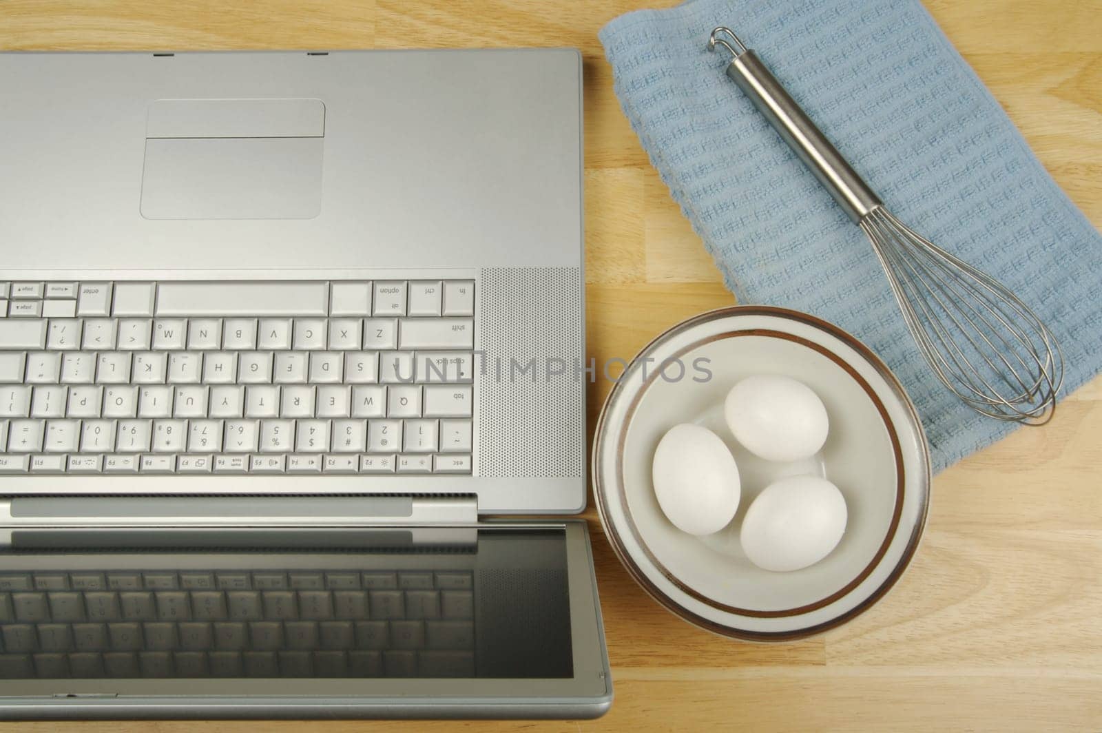 Laptop, eggs and mixer - online research for cooking and recipe information.