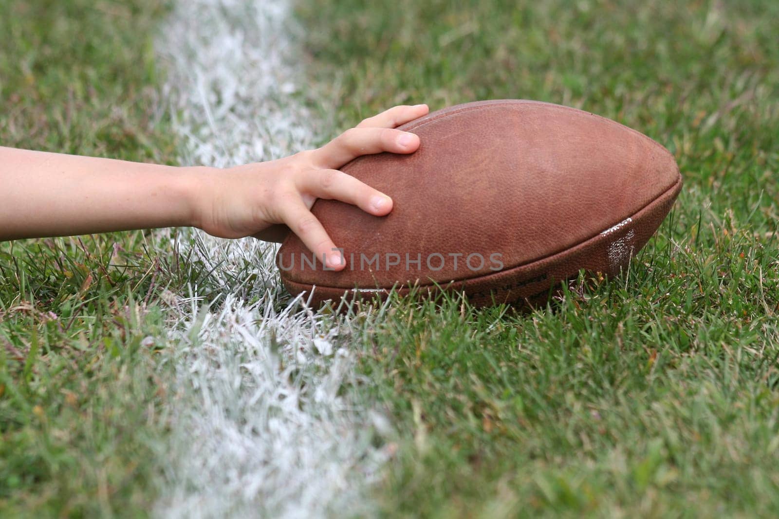 Hand with football reaches over white line