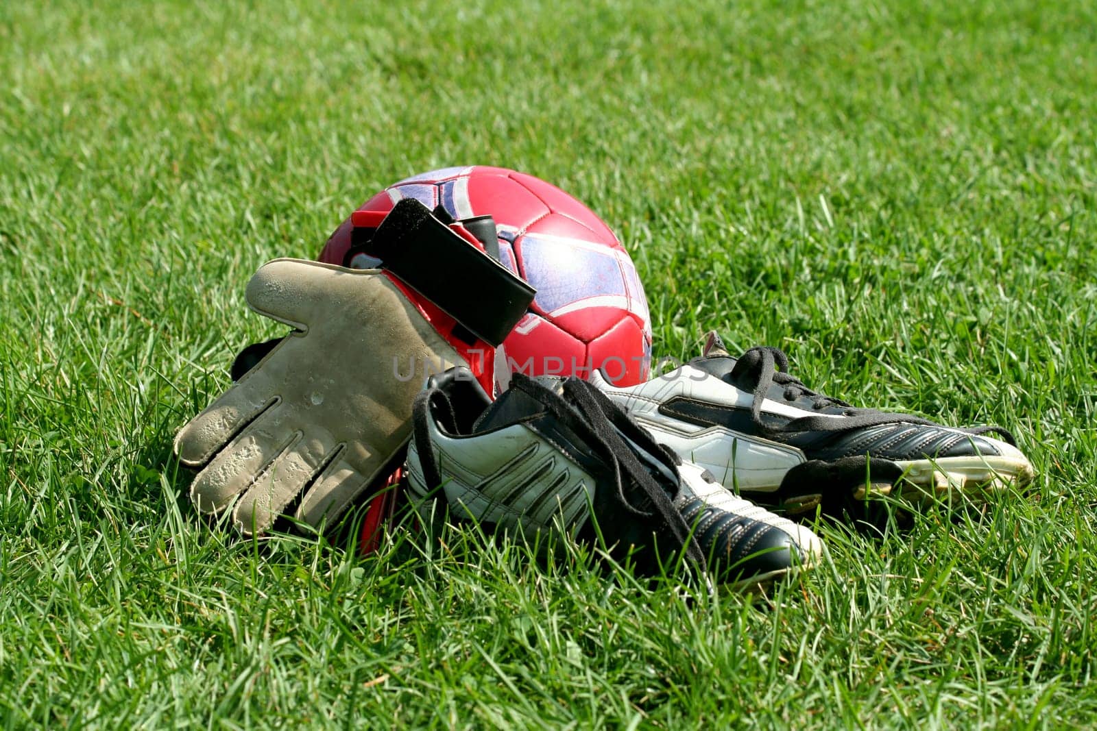 Ball, gloves and cleats at a field