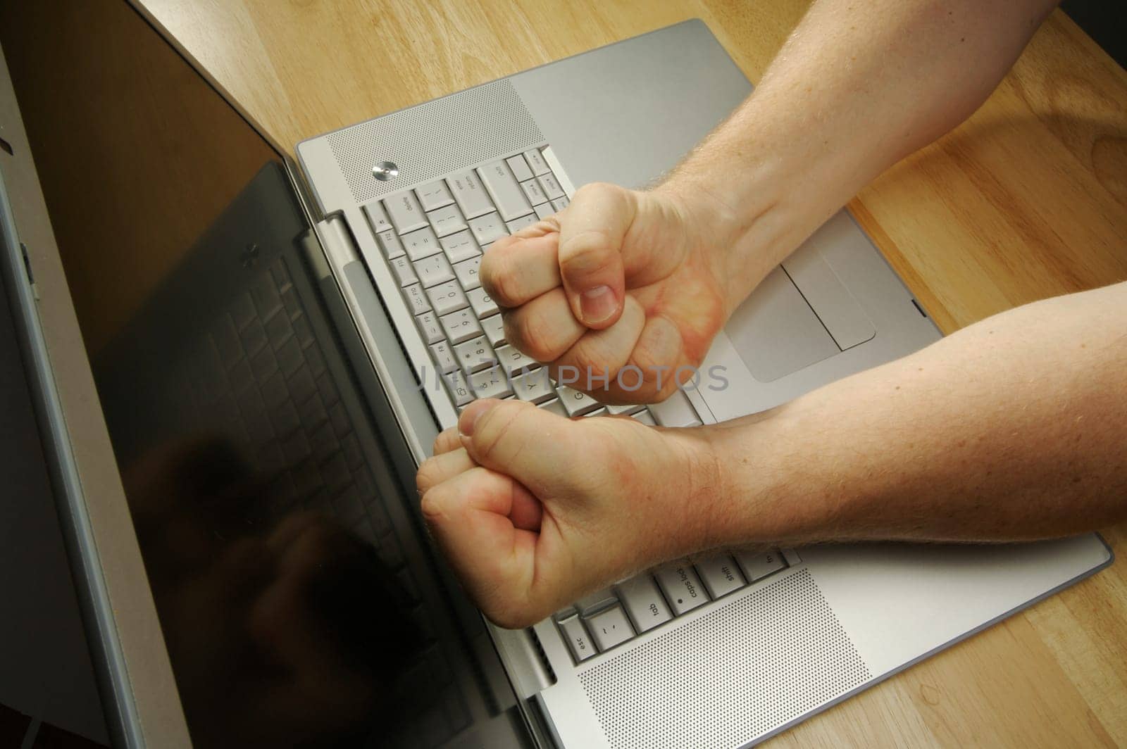 Frustrated businessman shows his frustration while working on his laptop.