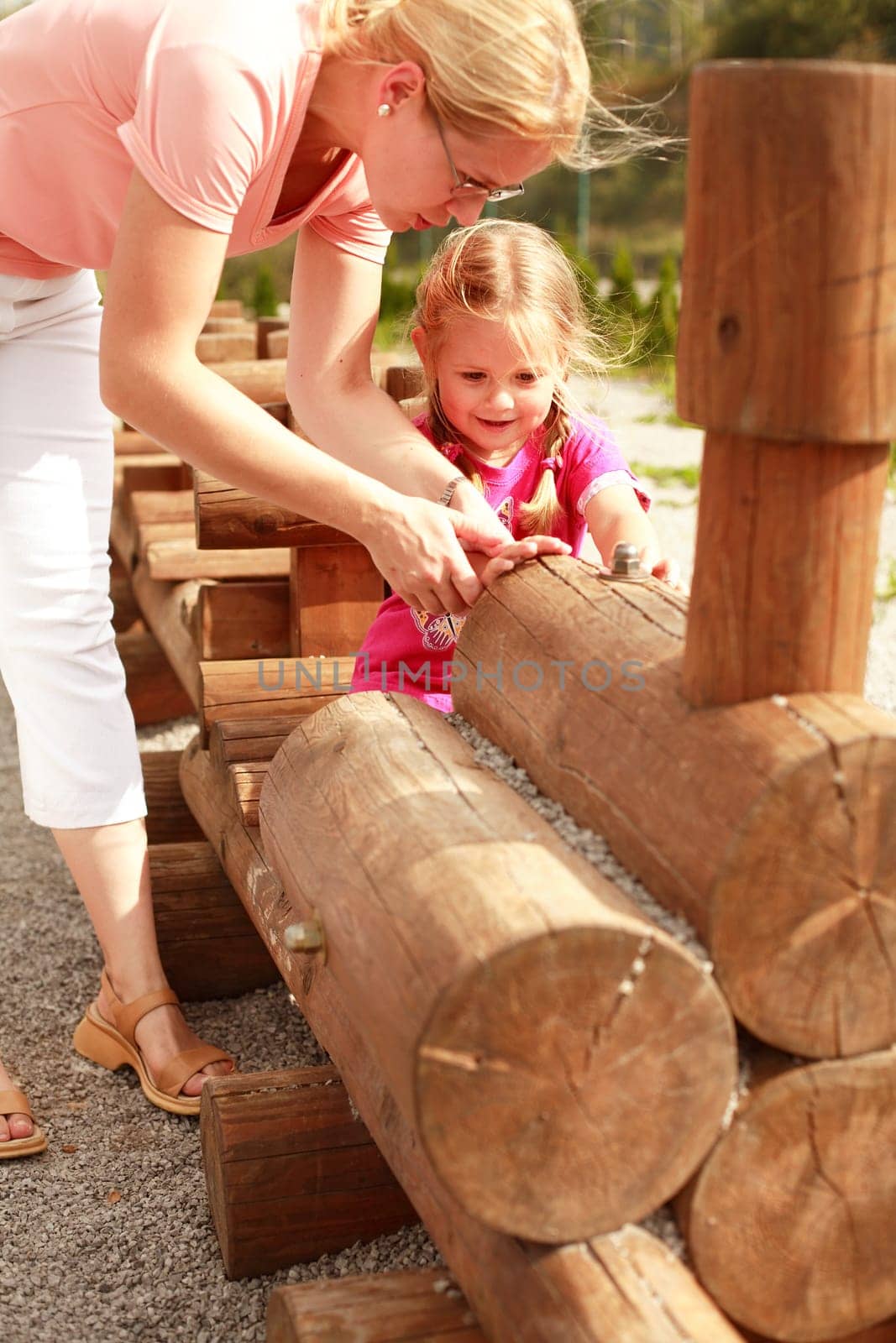 Mother and her daughter have fun at the playground