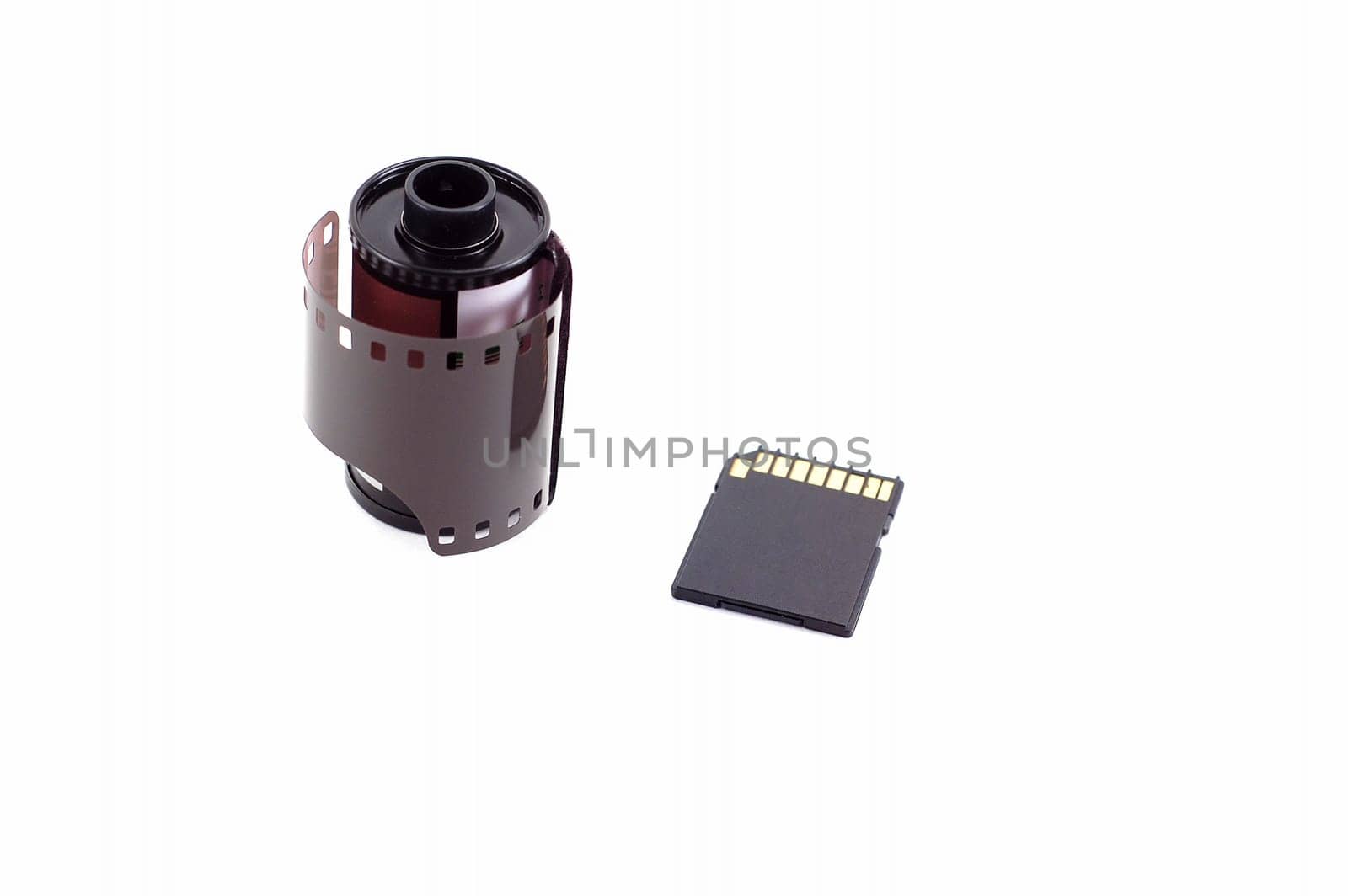 Roll of film next to a SD memory card