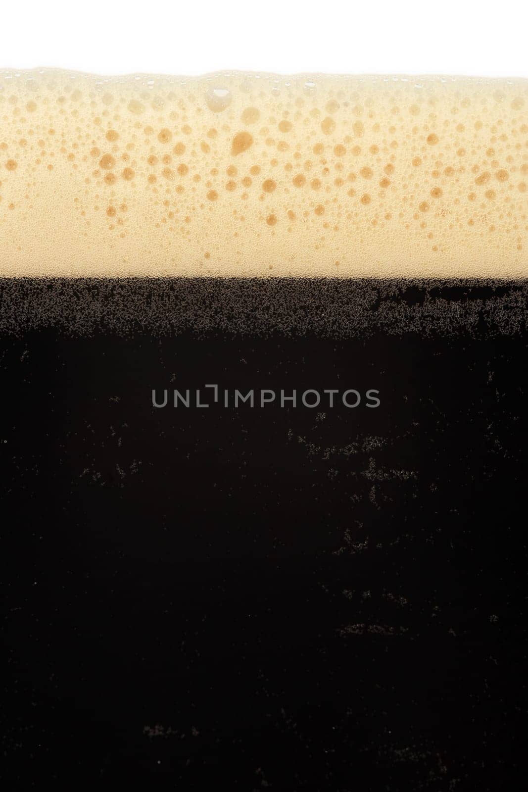 A macro image of a glass of stout beer or bitter.