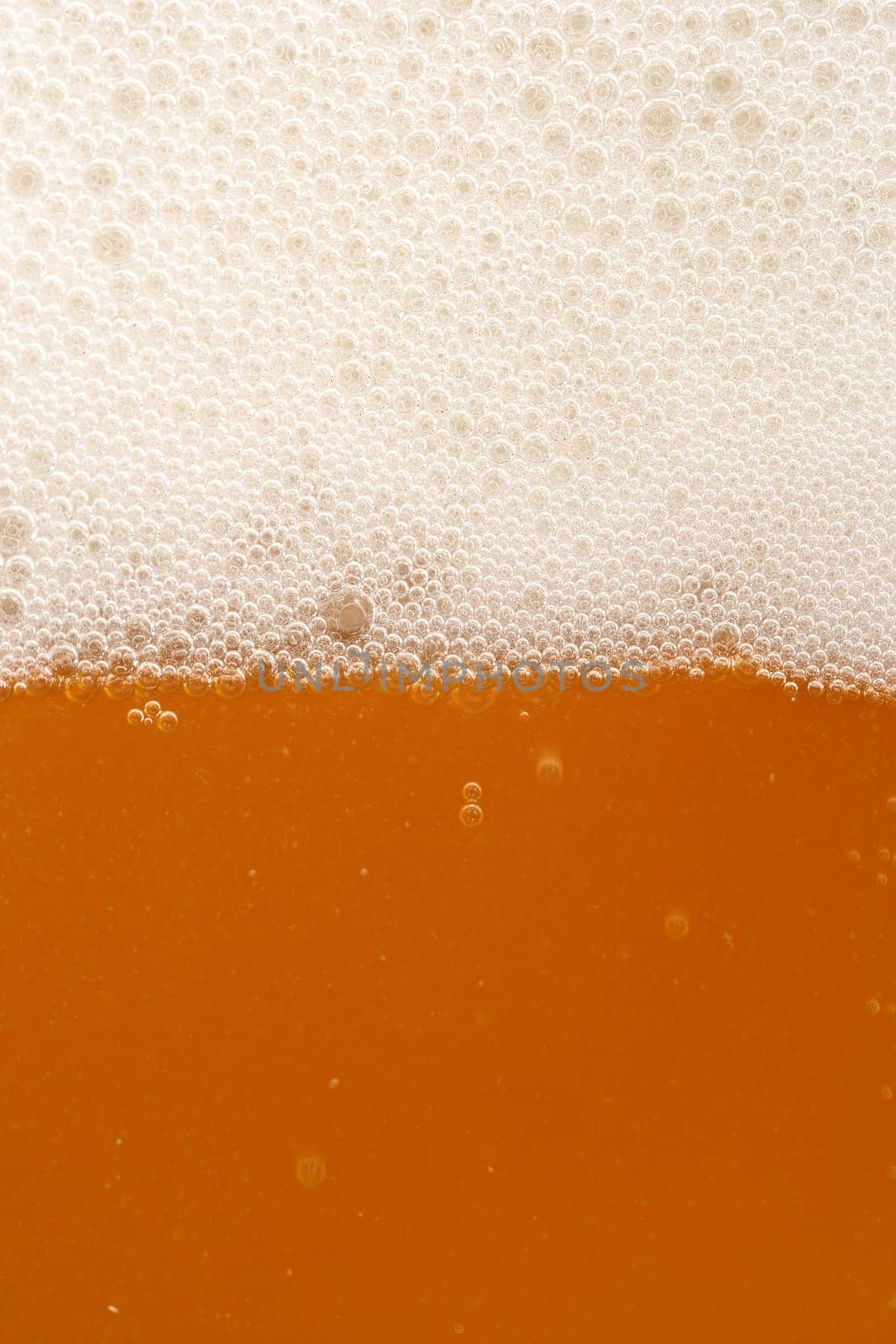 A macro image of a glass of amber beer.