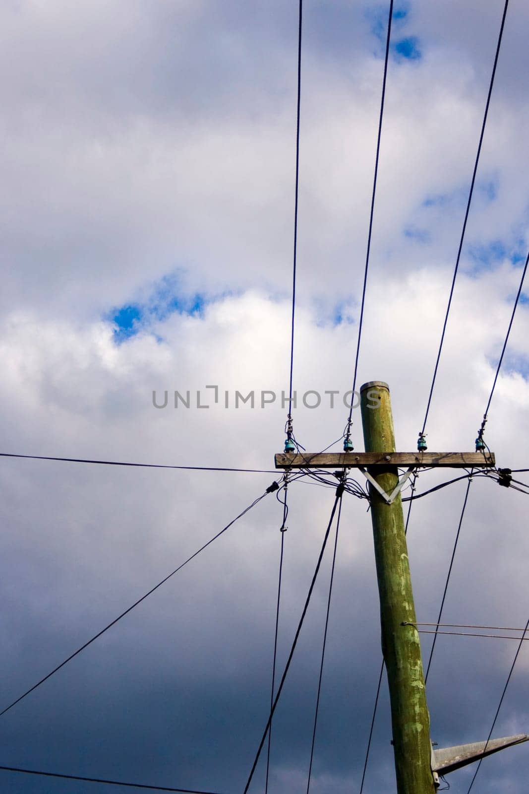 a power line pole against cloudy sky