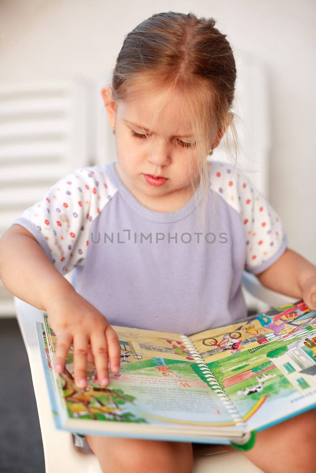 Cute child reading a picture book