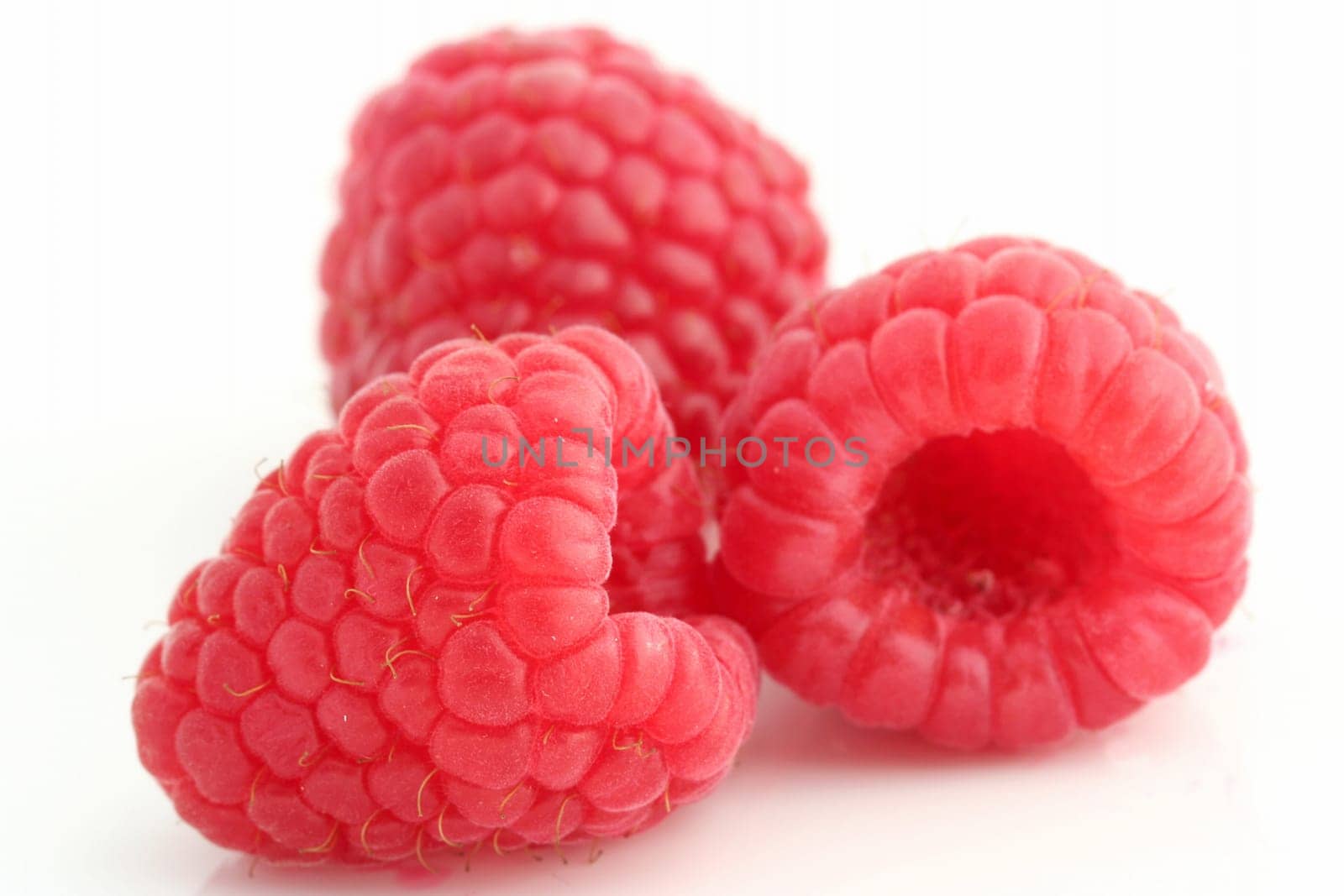 Three raspberries on white back ground