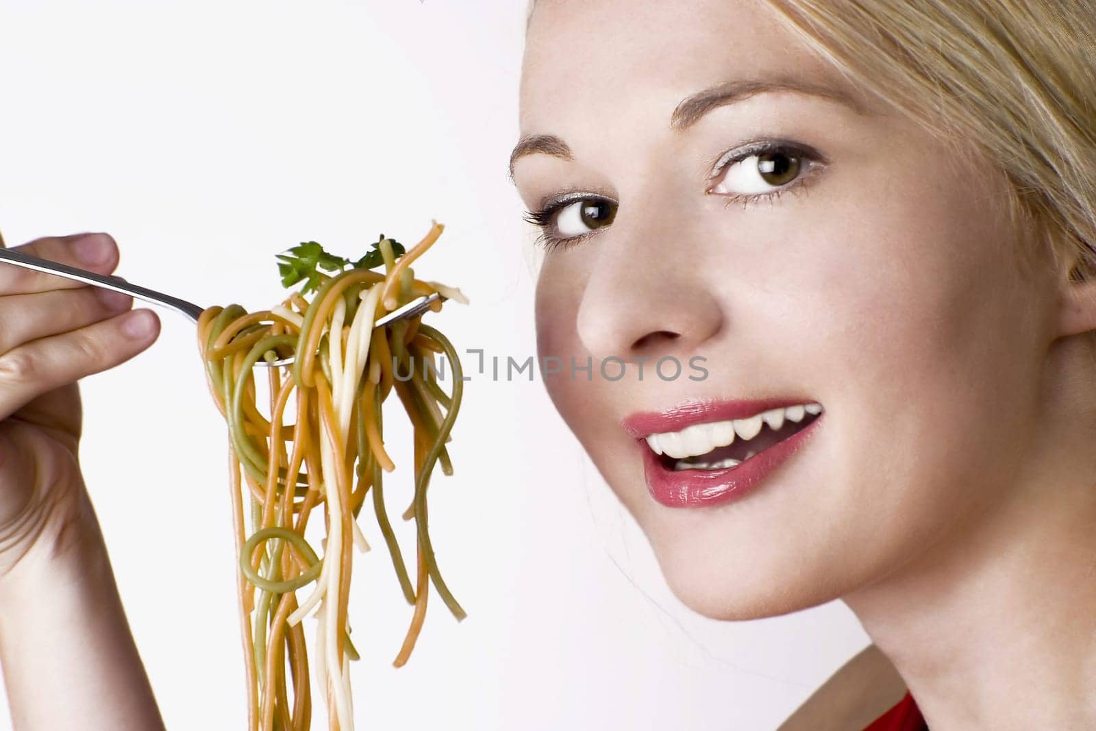 Woman eating colorful spaghetti. White background.