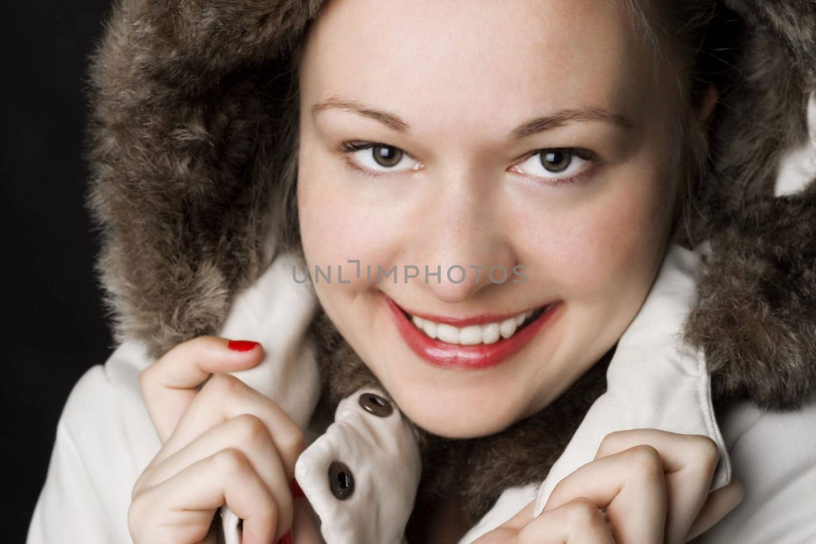 Woman wearing winter hooded jacket. Smiling blonde.