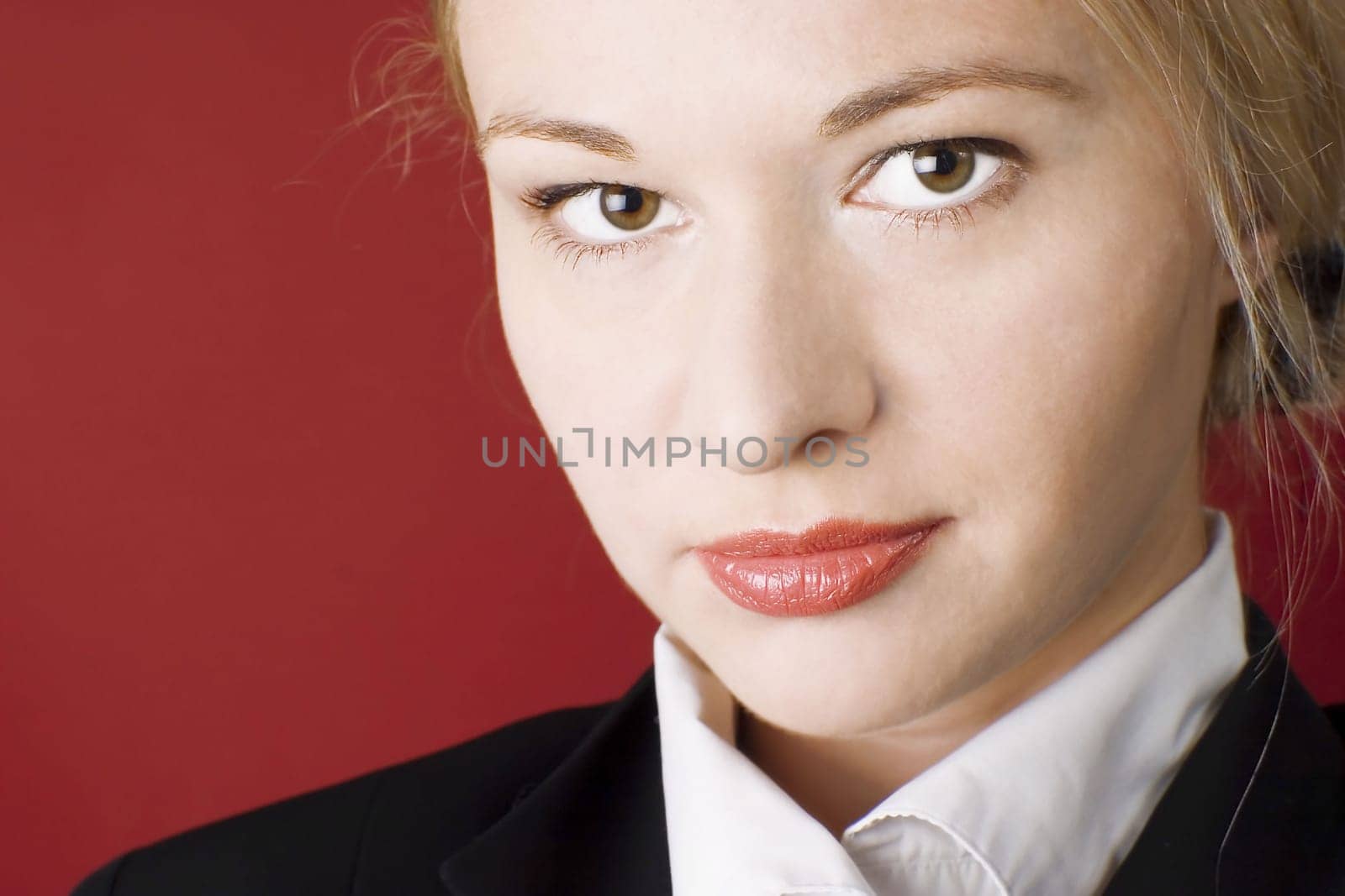 Businesswoman wearing black suit. Red background.