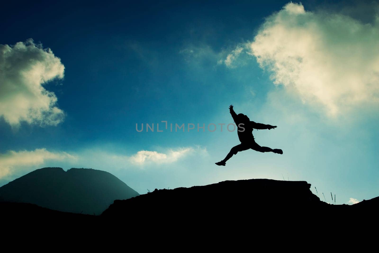 a man jumping on top of a rock