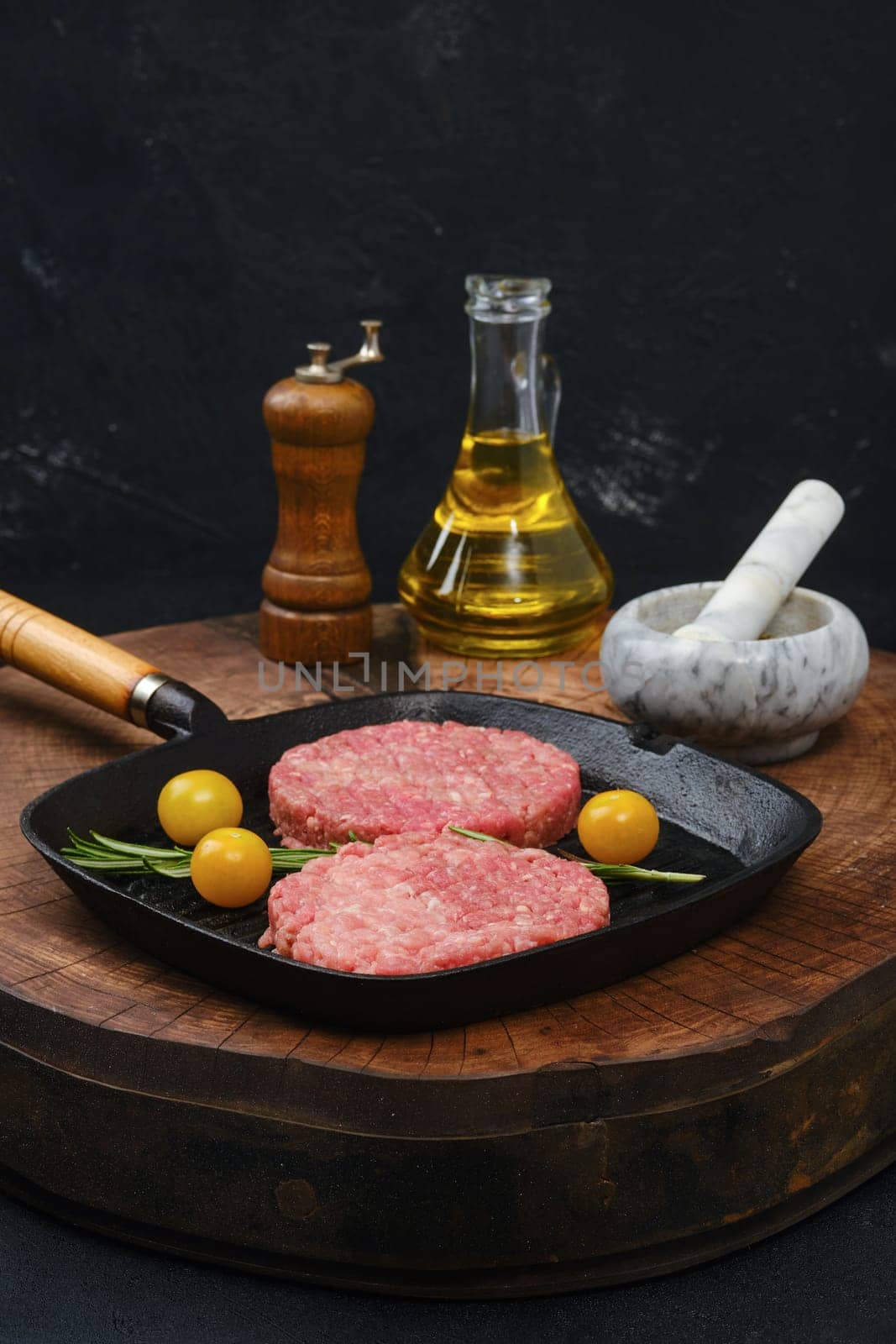 Raw beef burger patty on cast iron pan
