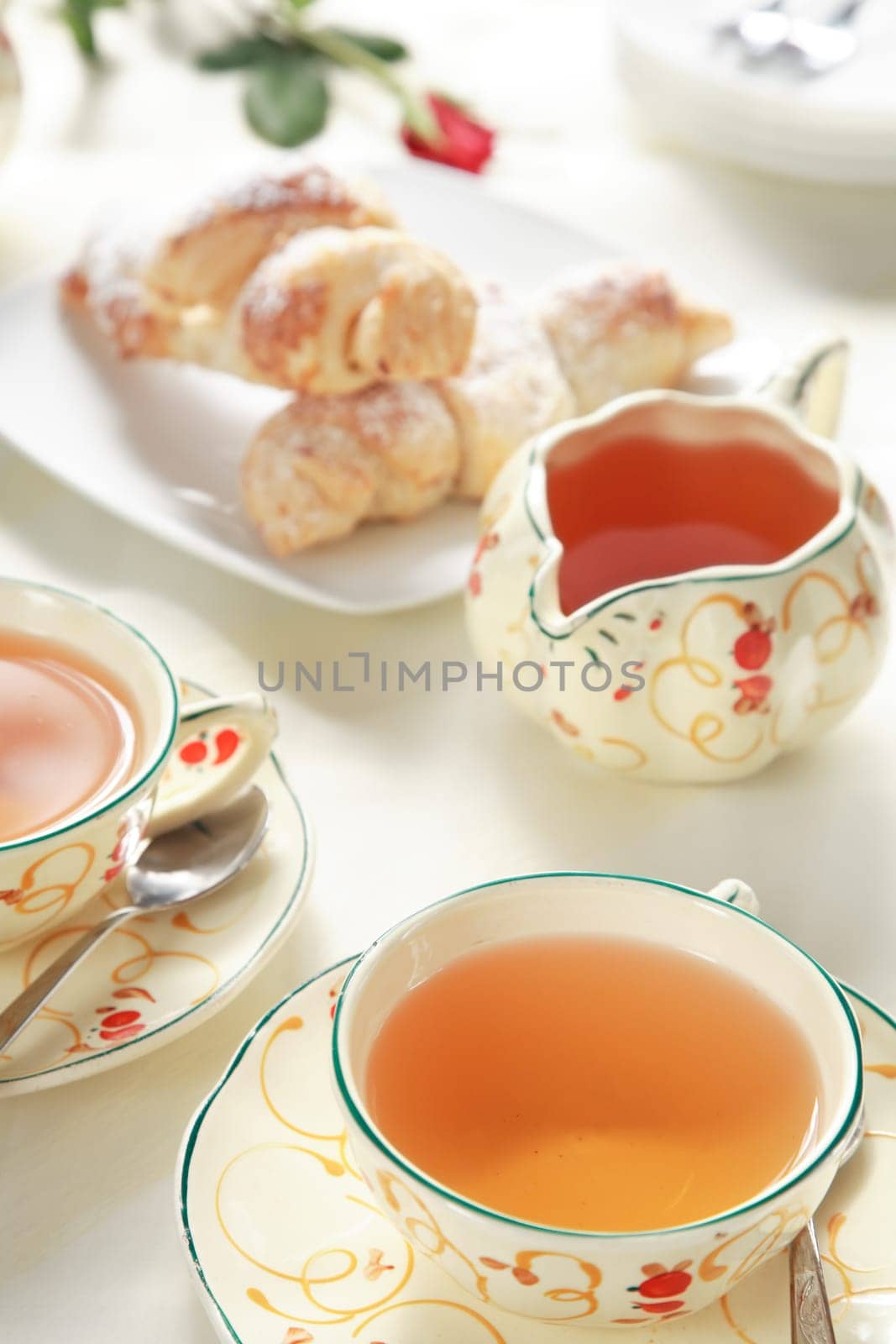 Two cups of tea with small sweet rolls