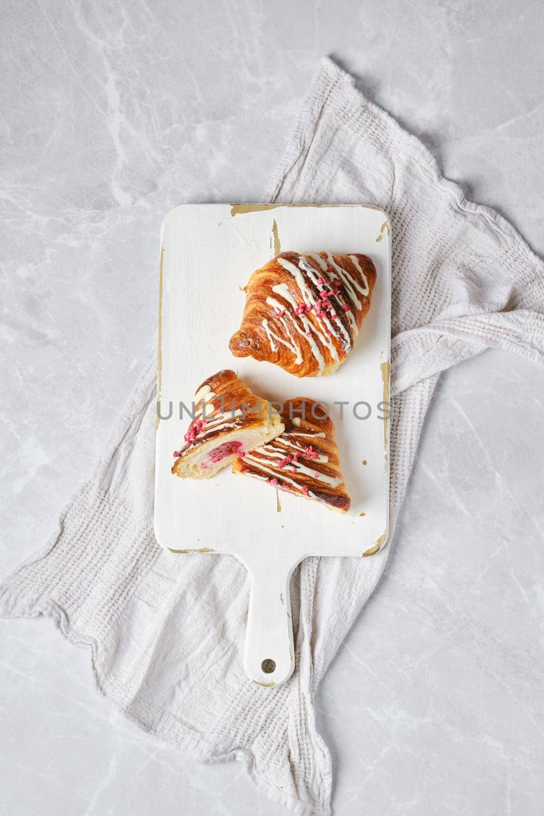 Top view of crispy croissant on wooden serving board