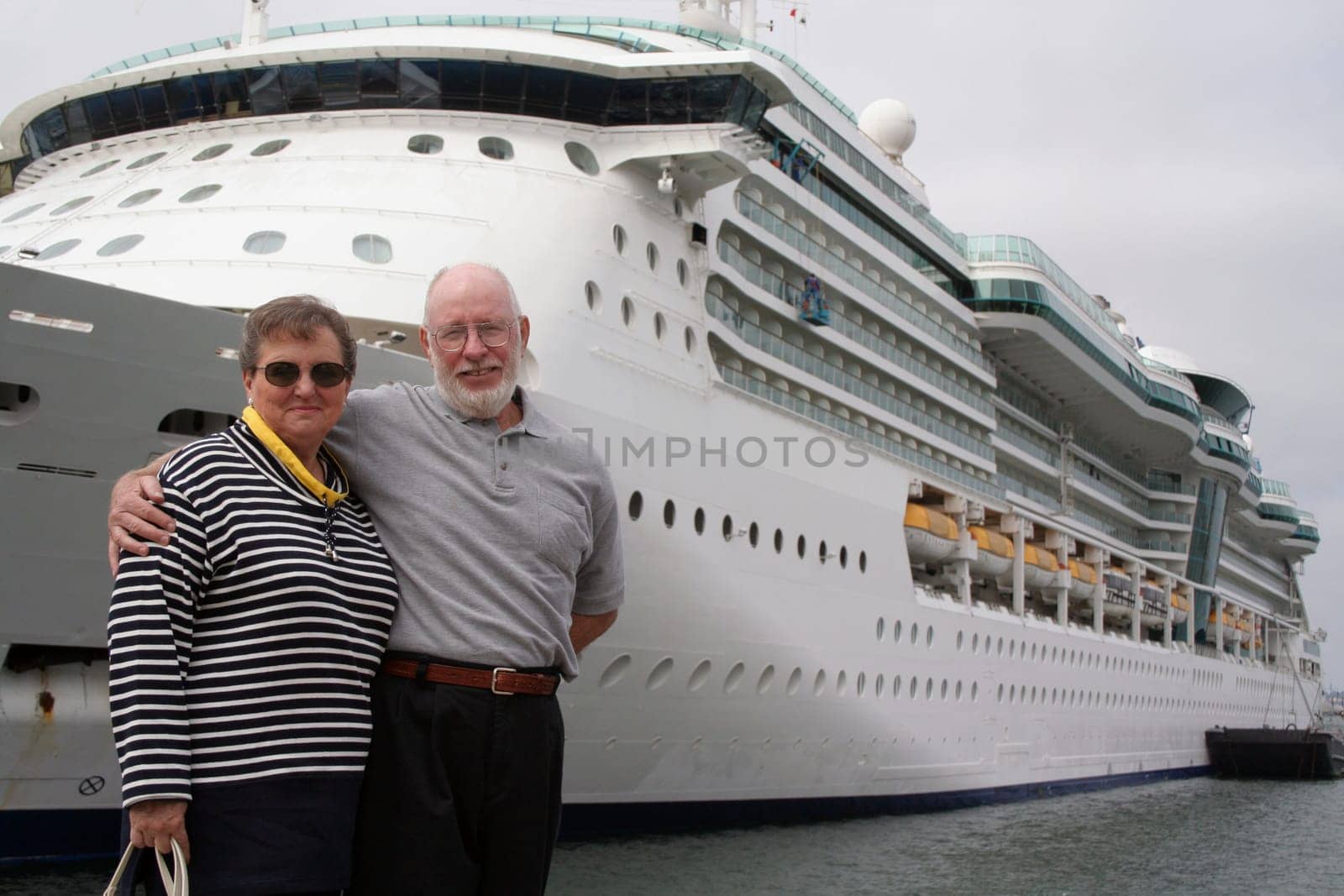 Senior couple ready for another cruise in front of a cruise ship.