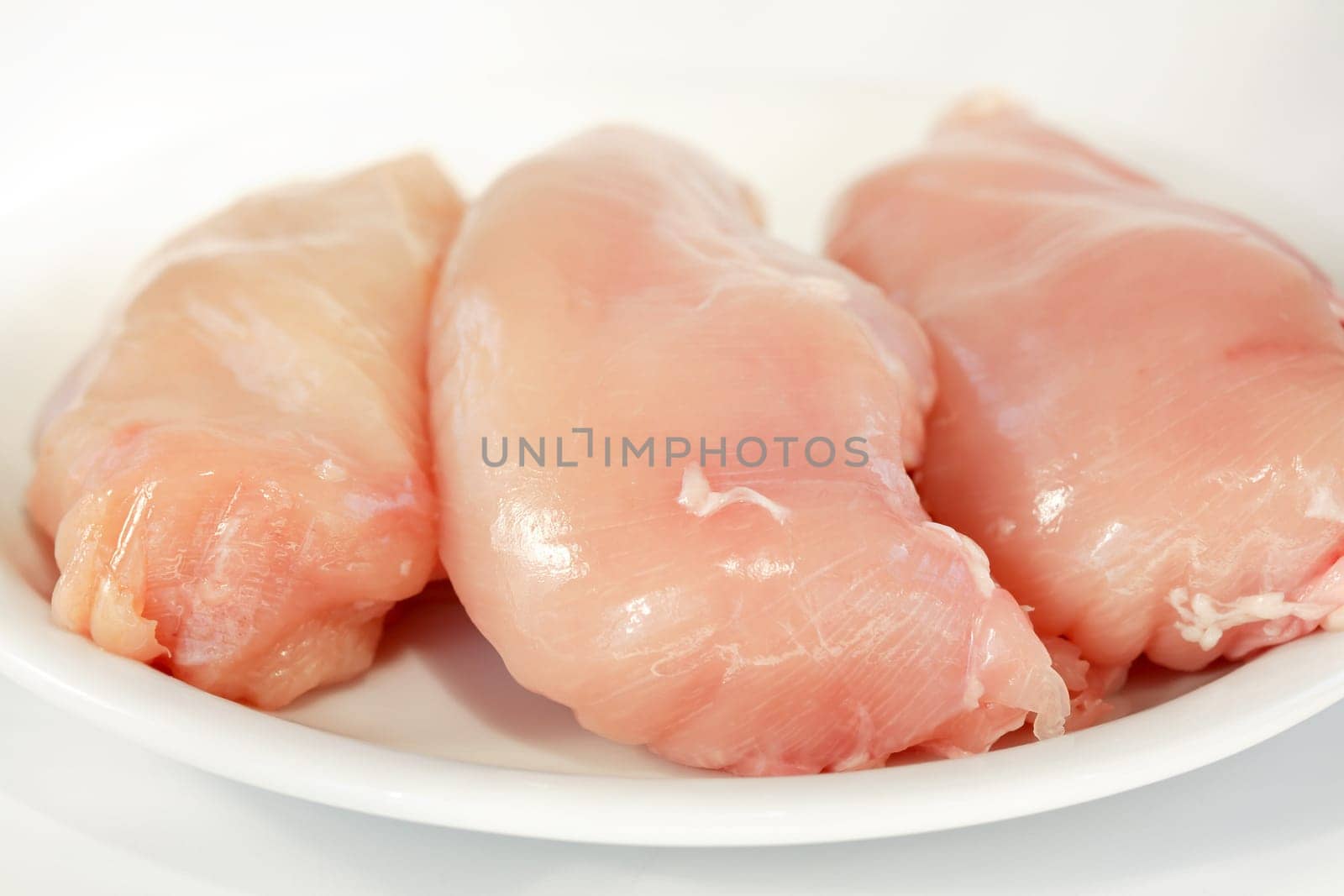Raw chicken breast on the plate