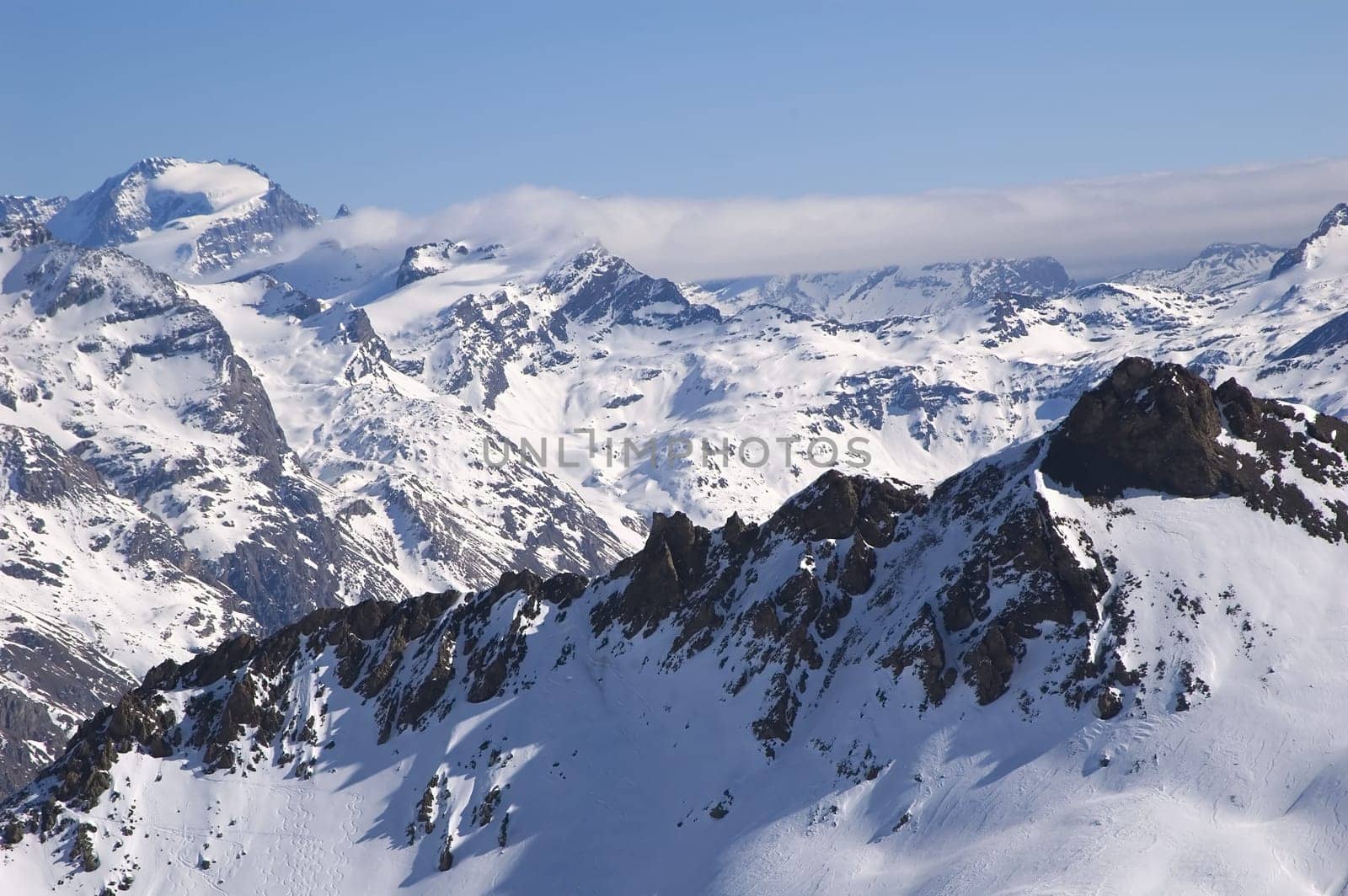 snowed mountainrange with visible rocks  and cloud