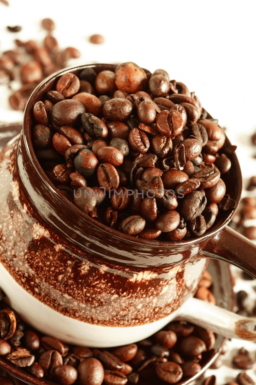 Cup of coffee beans on white