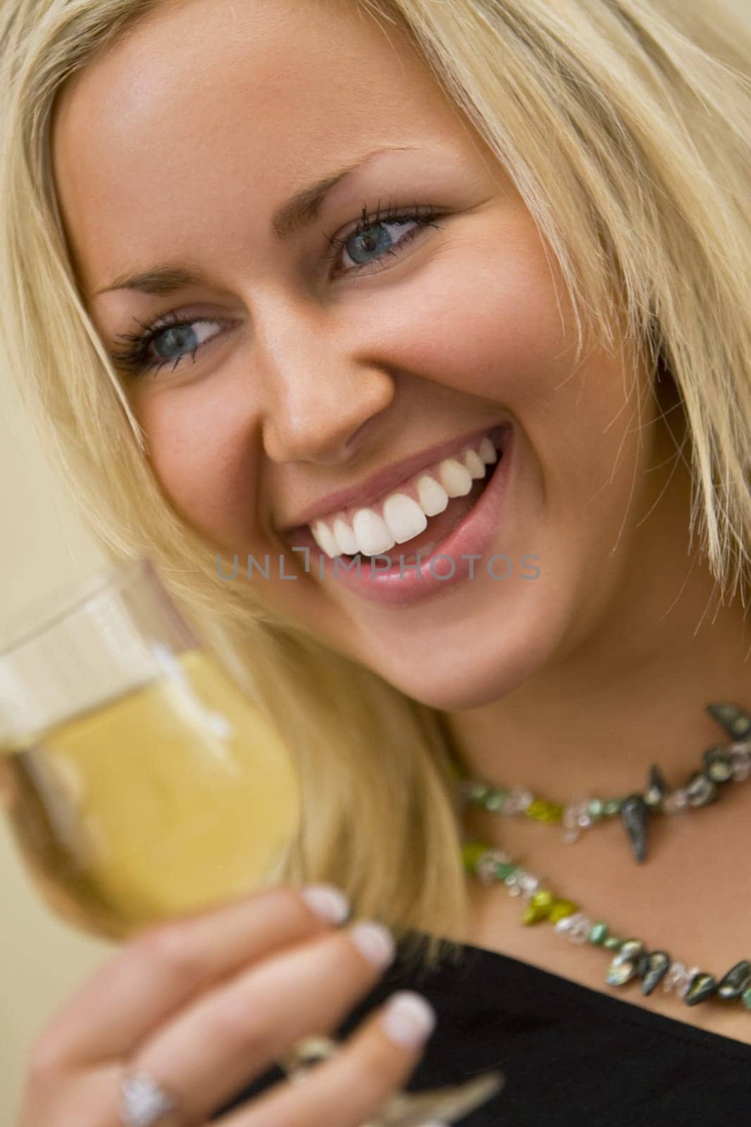 A beautiful young woman drinking a glass of white wine and having fun