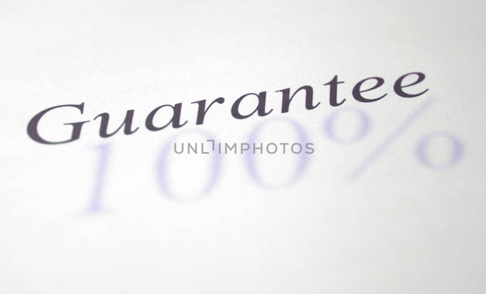 word 100% guarantee written on a white paper symbol of perfection