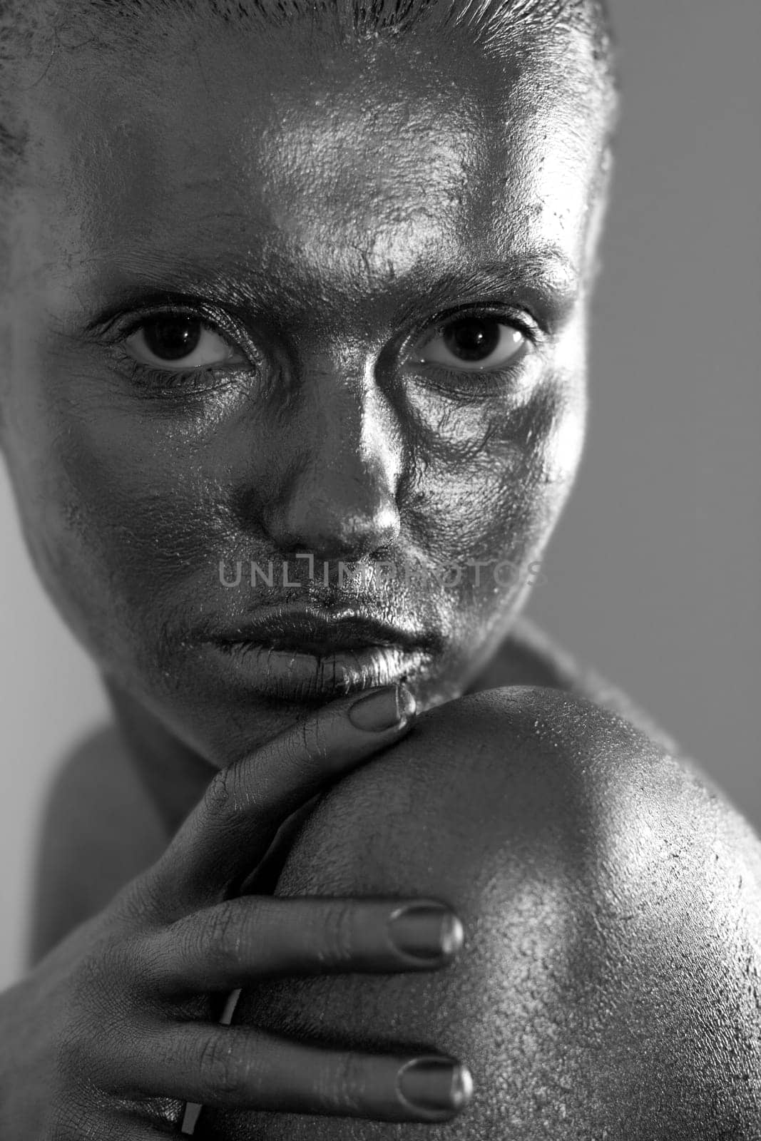 an attractive young girl covered with silver paint