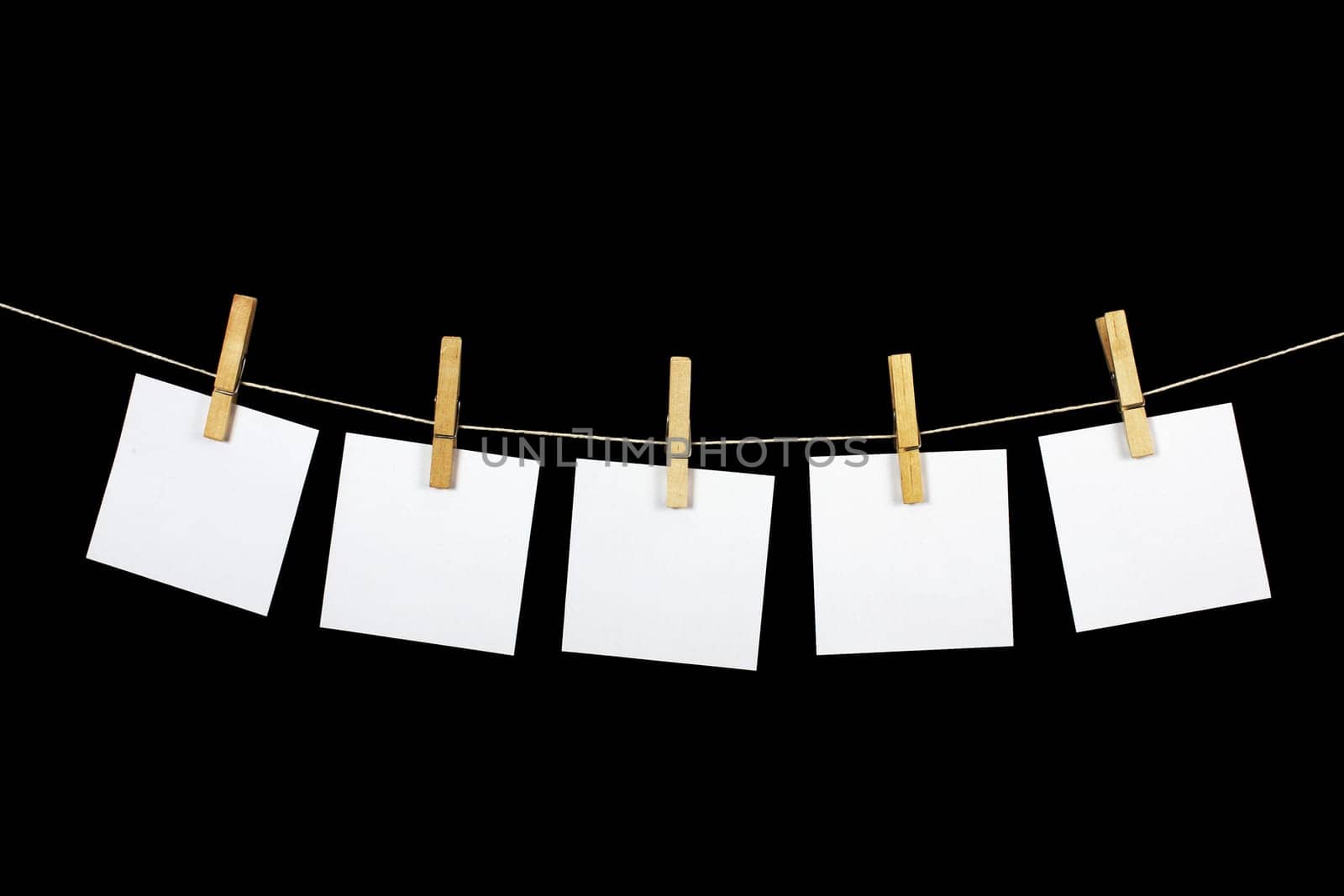 clothespins with paper on black background