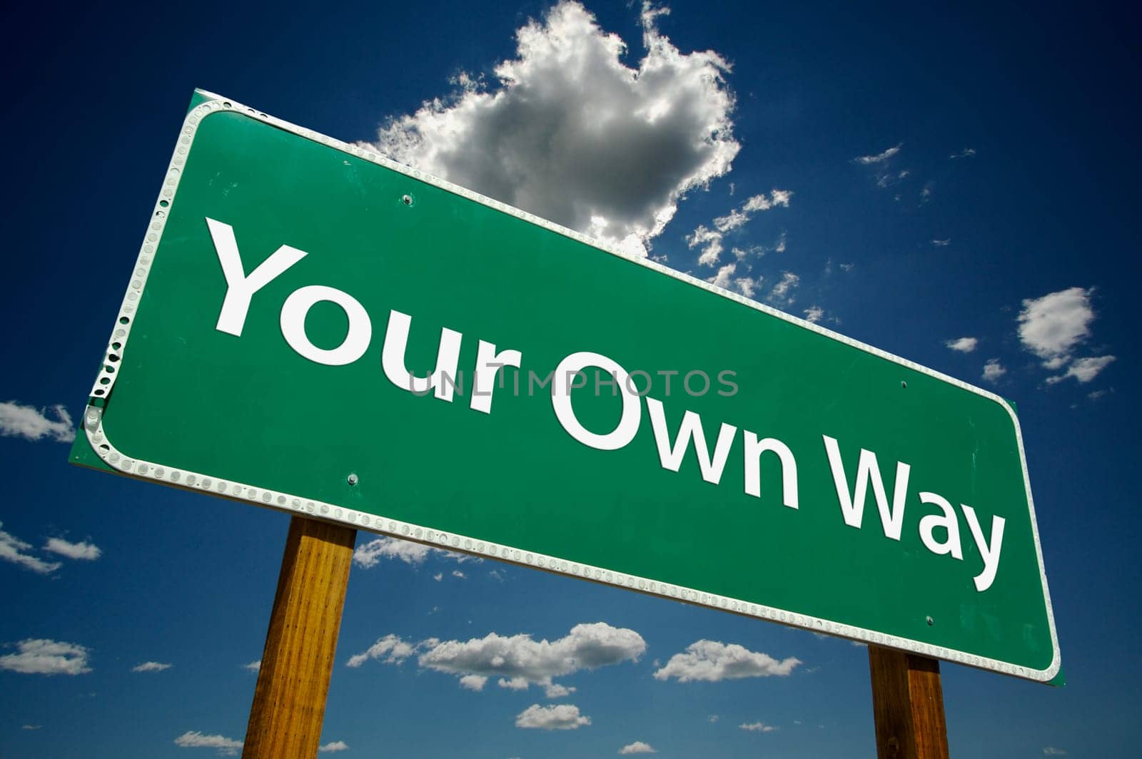 Your Own Way Road Sign with dramatic blue sky and clouds.