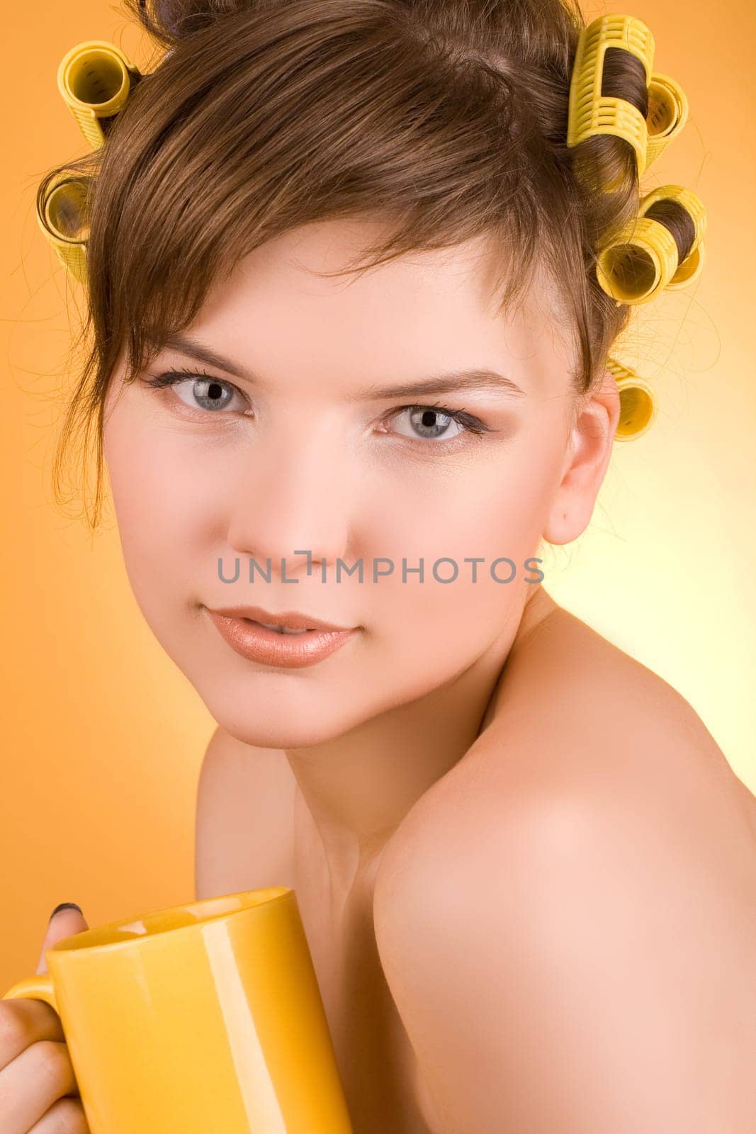 girl with hair-rollers holding a coffee cup